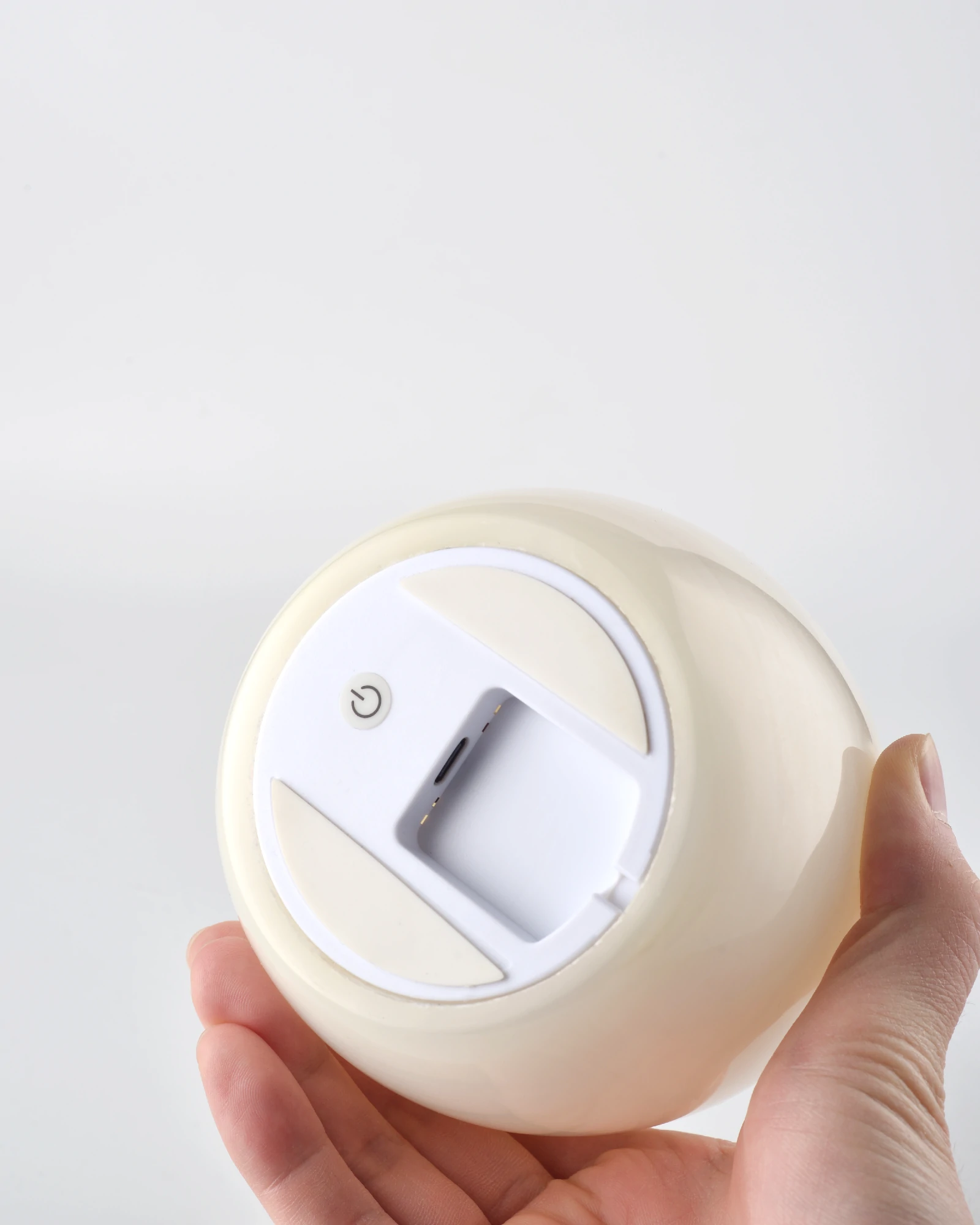 Close-up of the bottom of the compact and delicate Egg-Shaped Onyx Tap Lamp, showing the switch and charging port