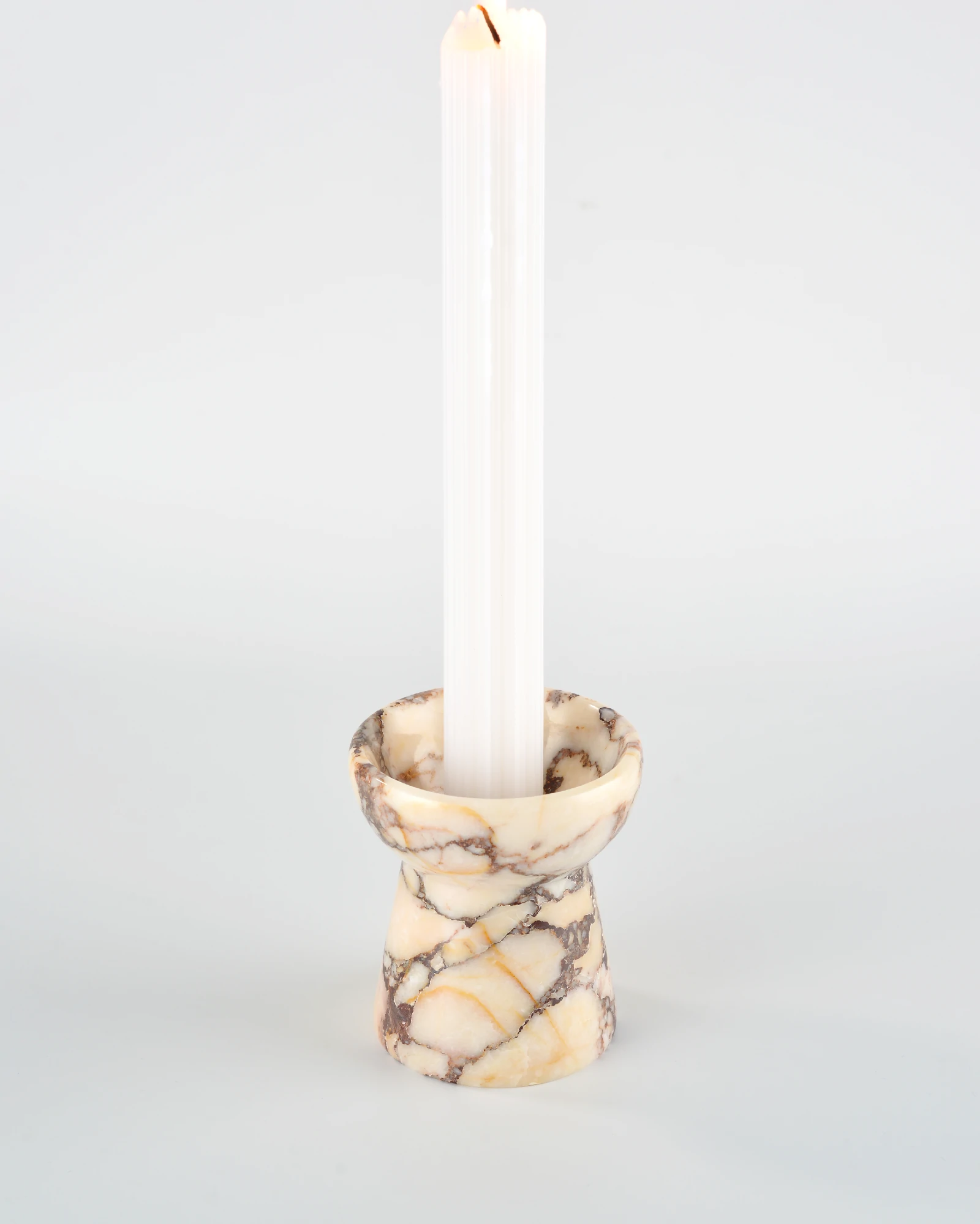 Rectangular aromatherapy candle placed on the small torch-shaped Calacatta Marble candle holder, showcasing its handcrafted design