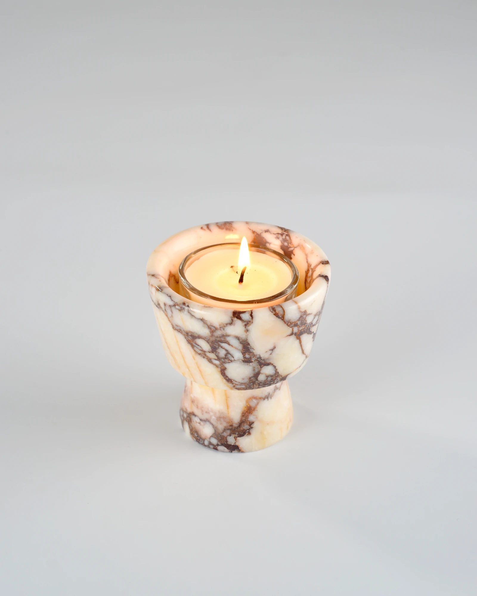 Aromatherapy candle on the Calacatta Marble "Cupcone" candle holder, showcasing the elegant design