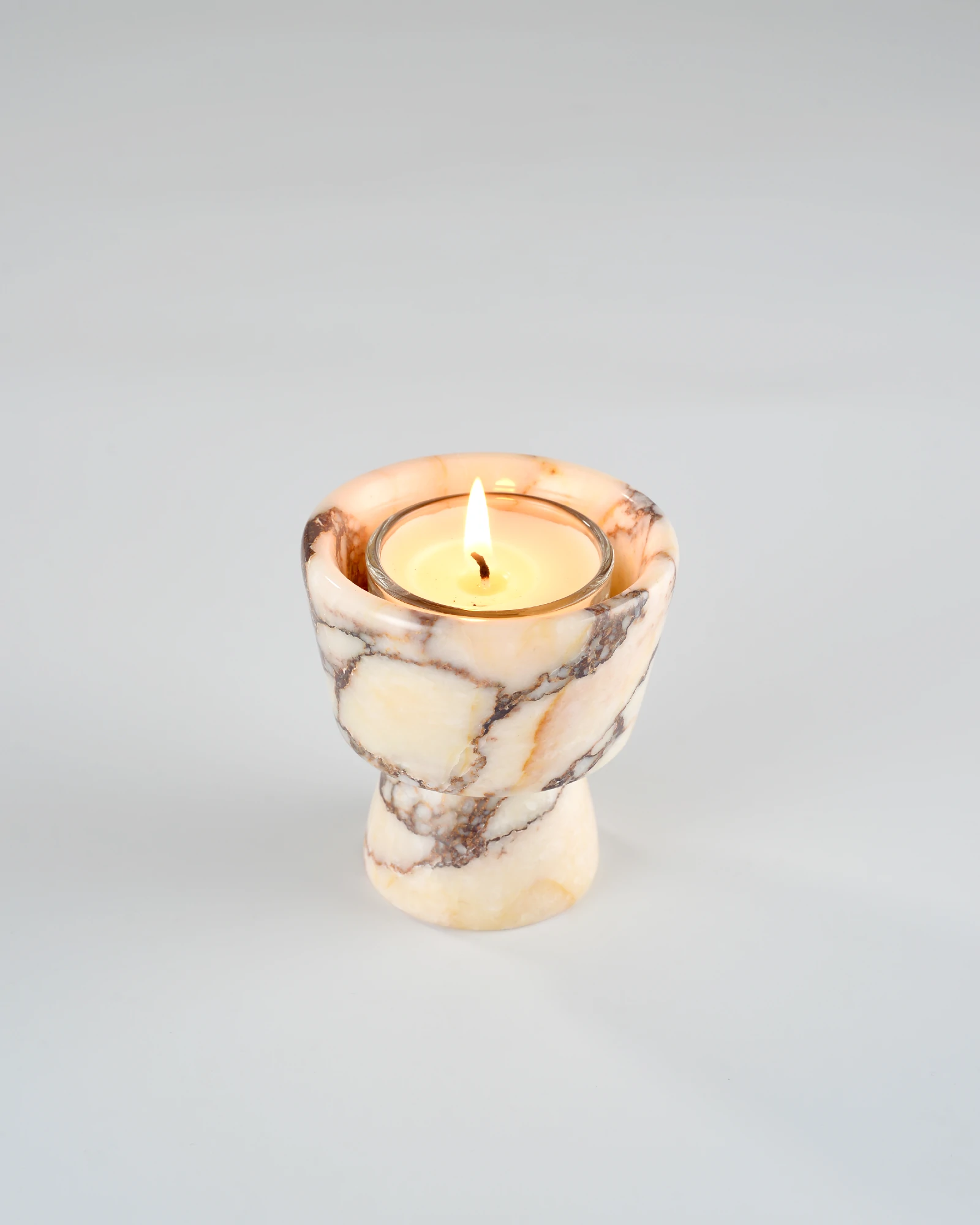 Aromatherapy candle resting on the handcrafted Calacatta Marble candle holder