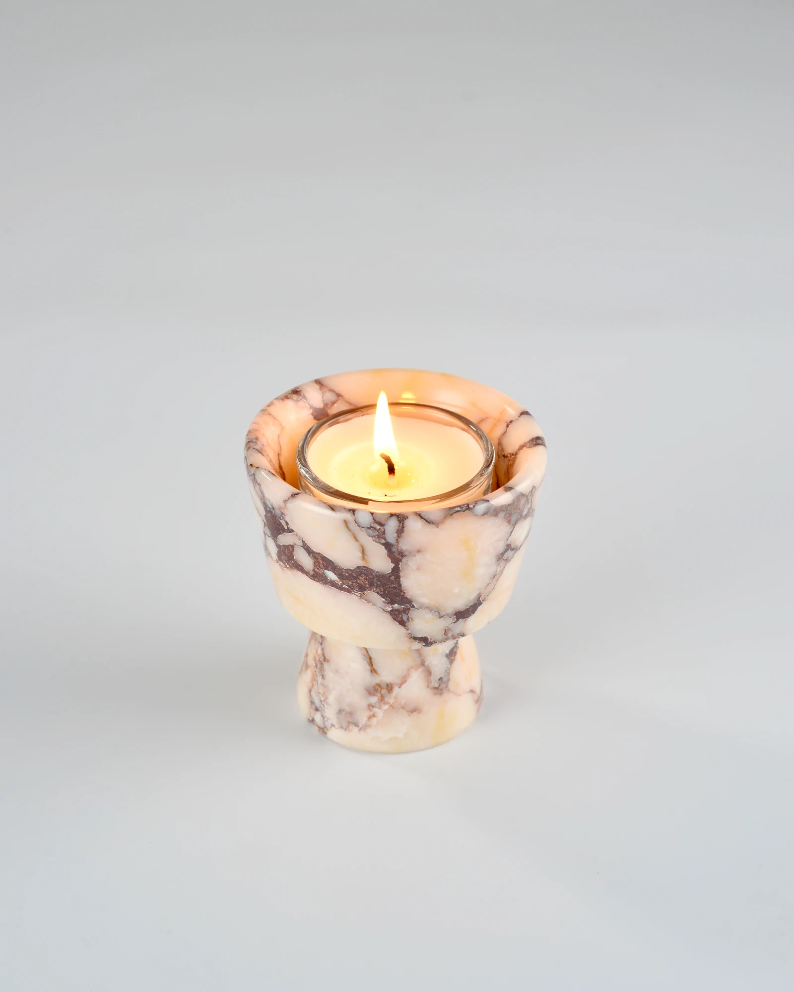 Aromatherapy candle placed on handcrafted Calacatta Marble candle holder