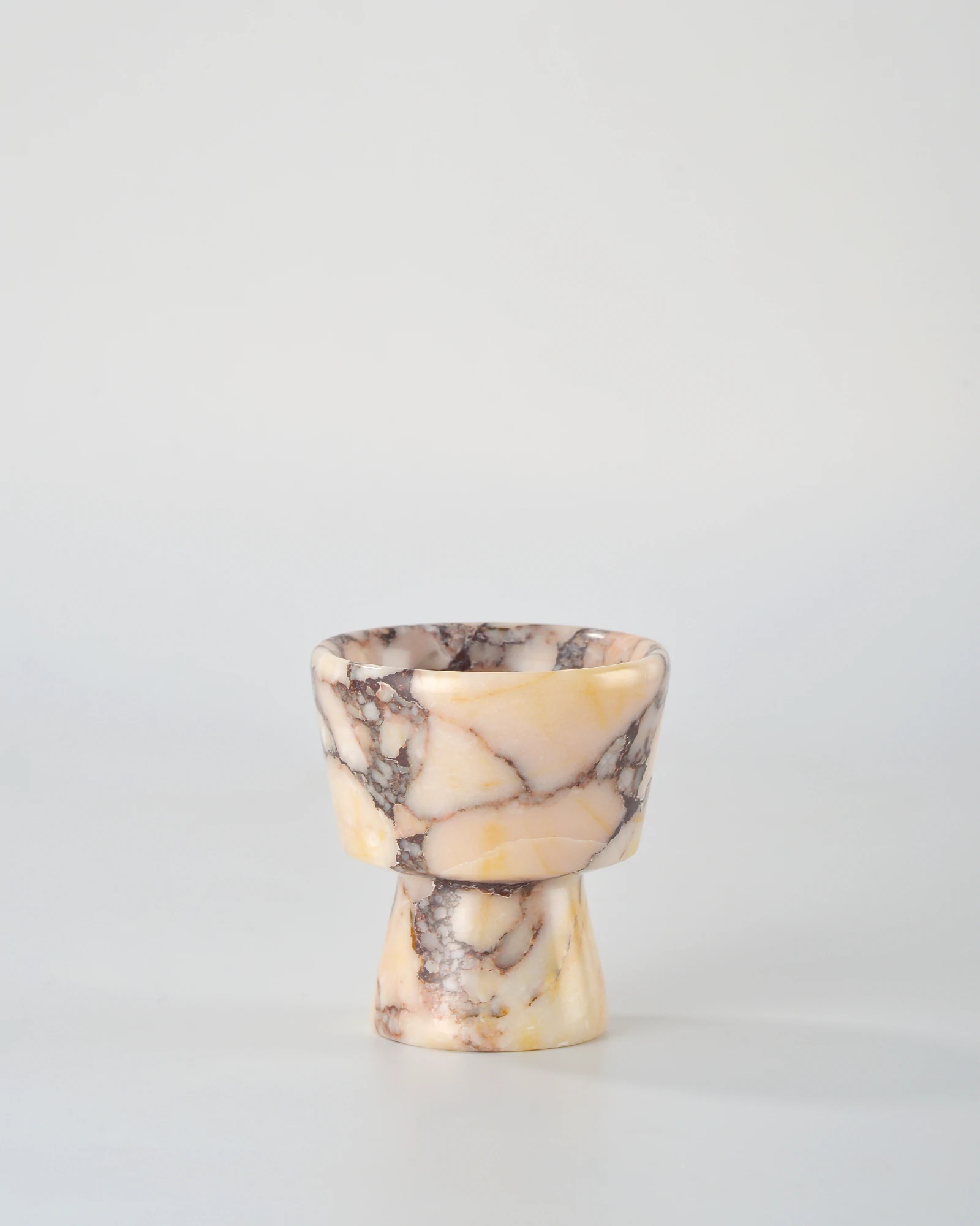 Geometric Calacatta Marble candle holder with delicate brown-red veining on a beige stone base