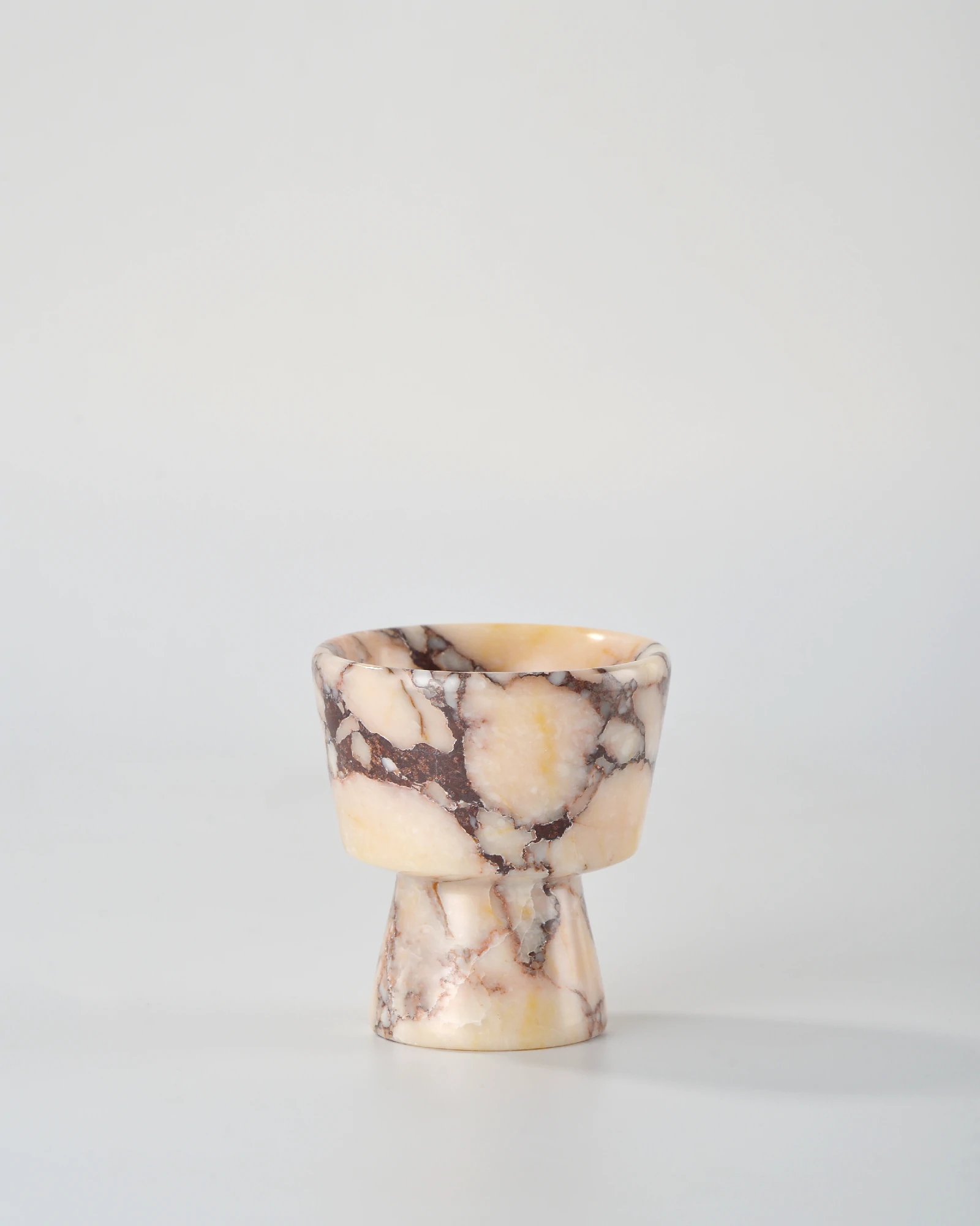 Handcrafted Calacatta Marble candle holder with brown-red veining and beige base, shaped in a classic geometric form