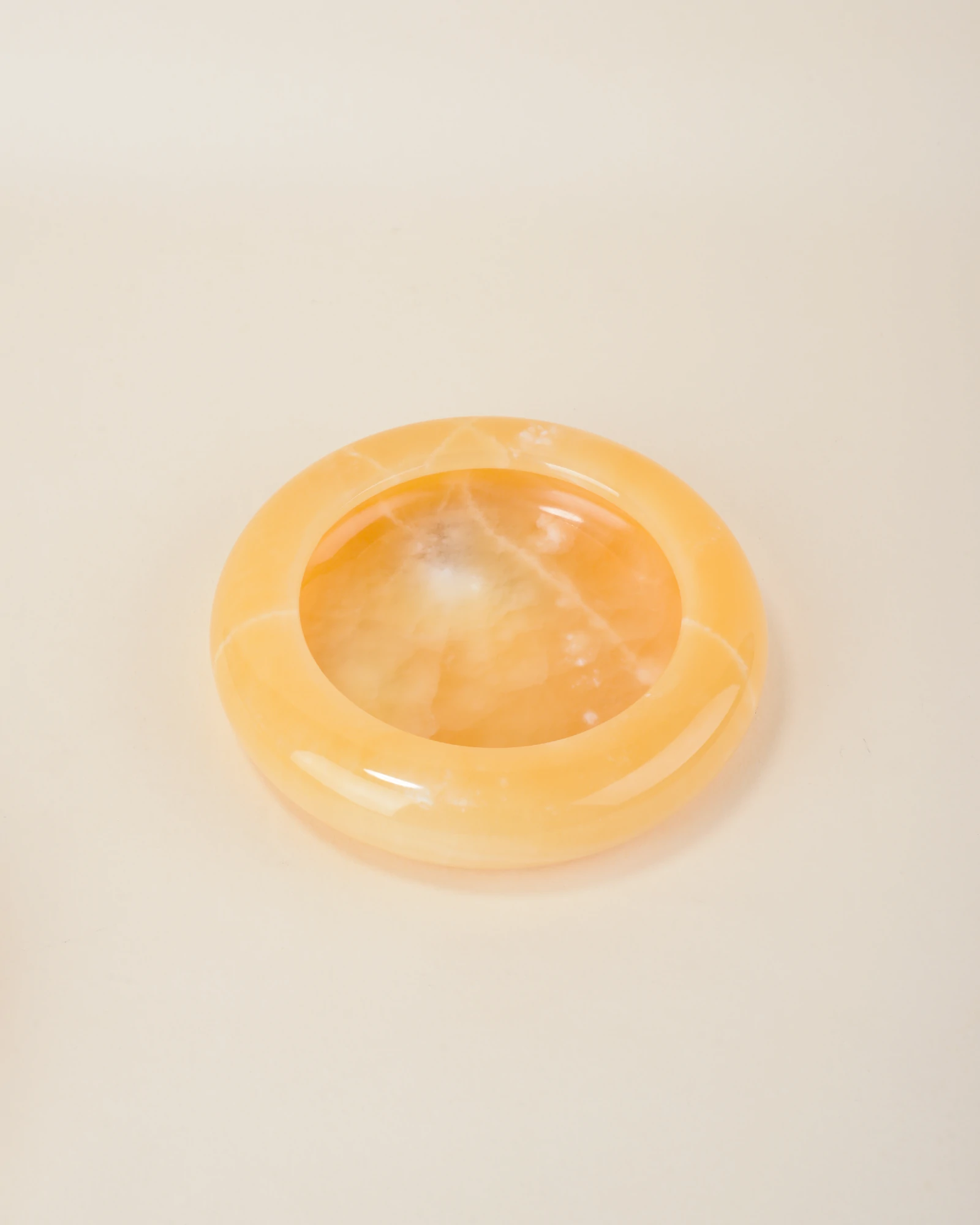 Handcrafted Round Orange Onyx Ashtray with smooth finish and natural white veining