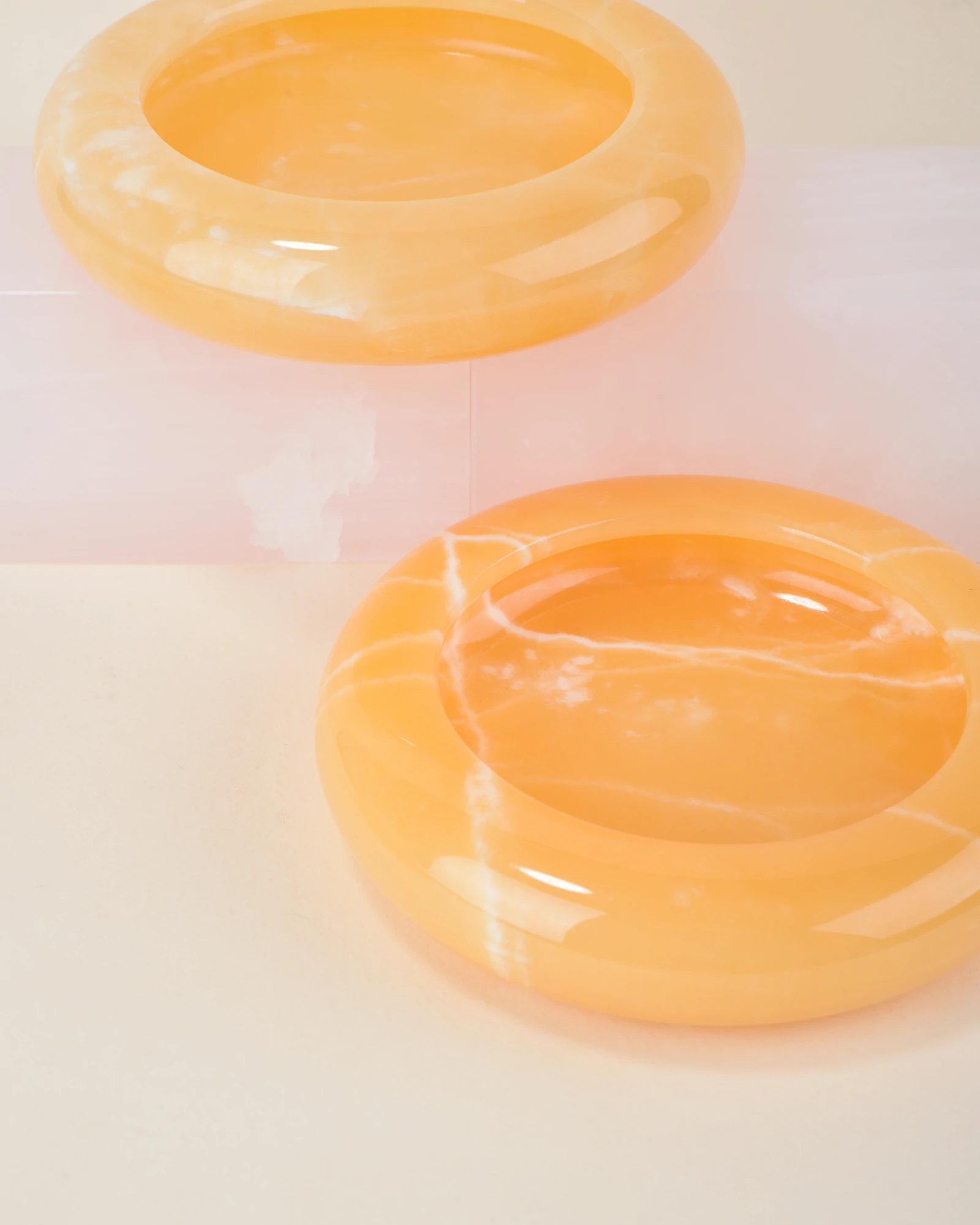 Group arrangement of polished Round Orange Onyx Ashtrays with natural white veining, designed for cigar and cigarette smokers