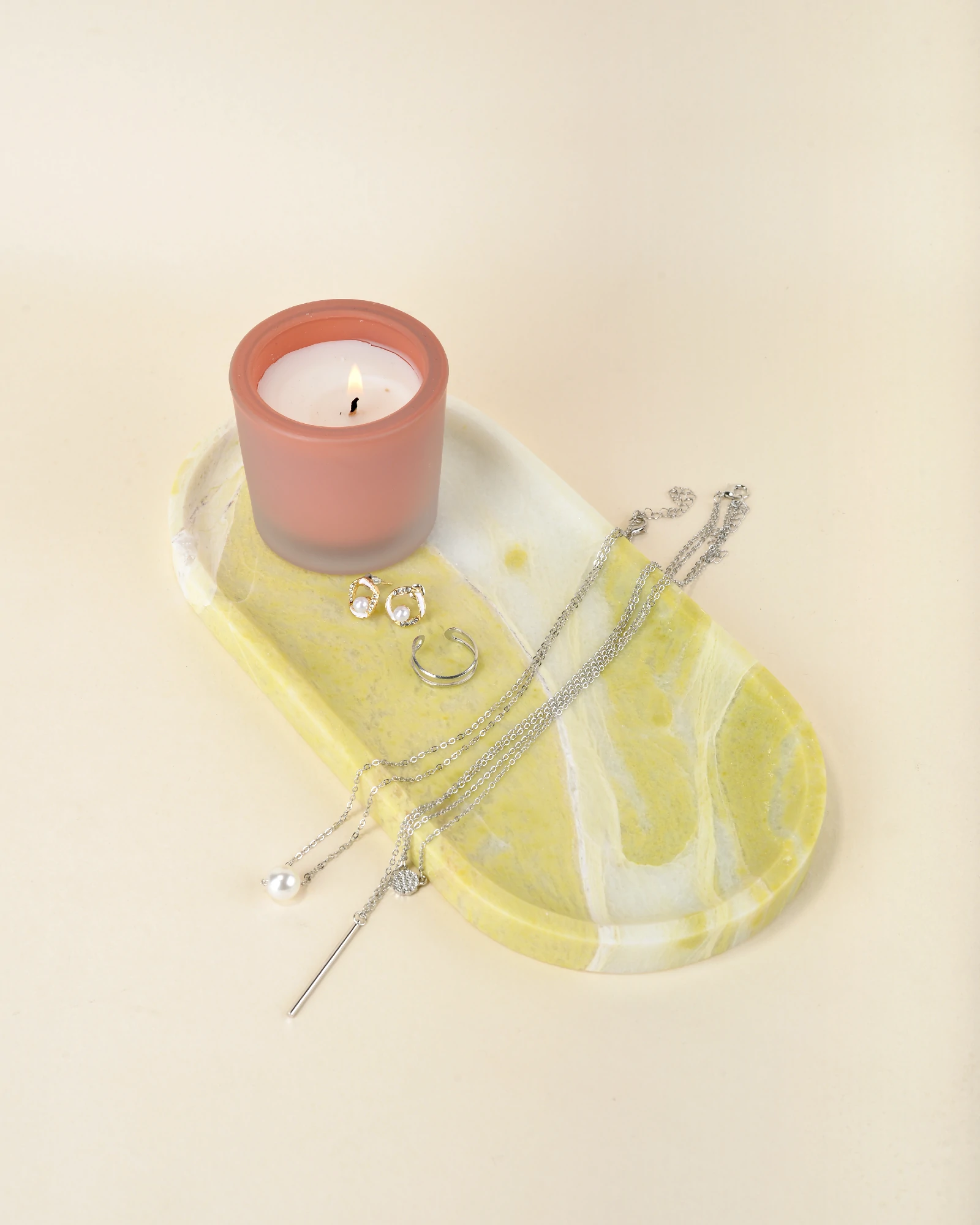 Jewelry placed on the elegant Oval Yellow Marble Tray, showcasing its smooth finish and unique natural veining