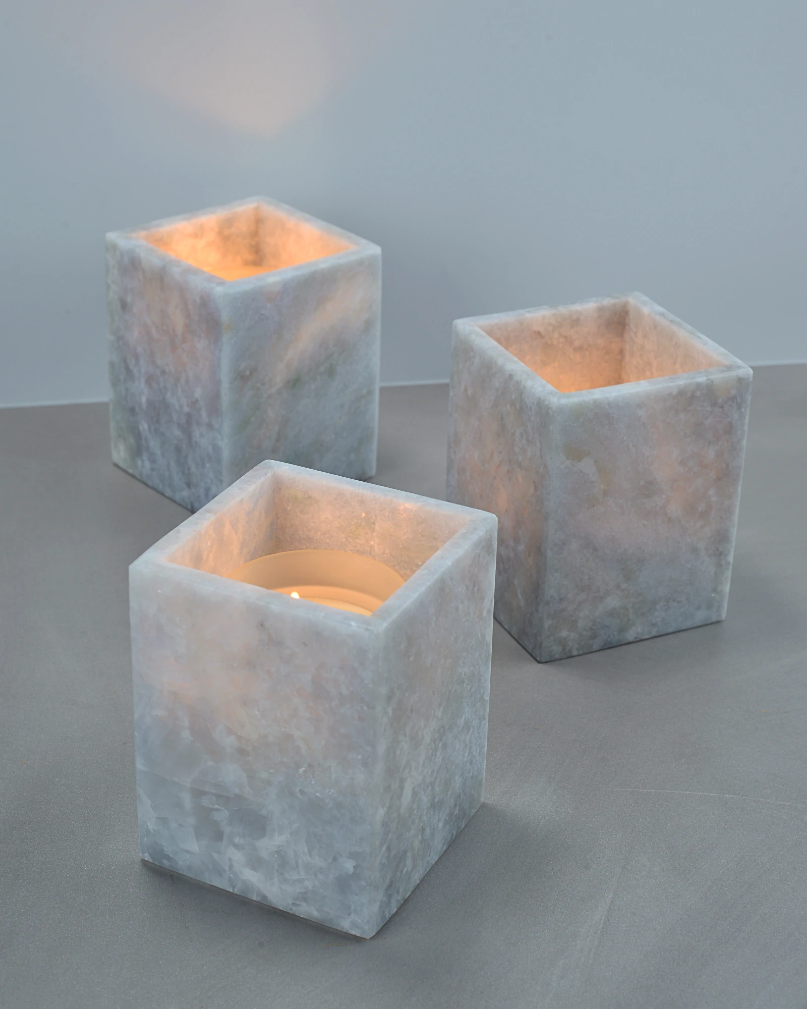 Multiple Blueish Crystal Marble Candle Holders with unique natural patterns, used as decorative accents on a table