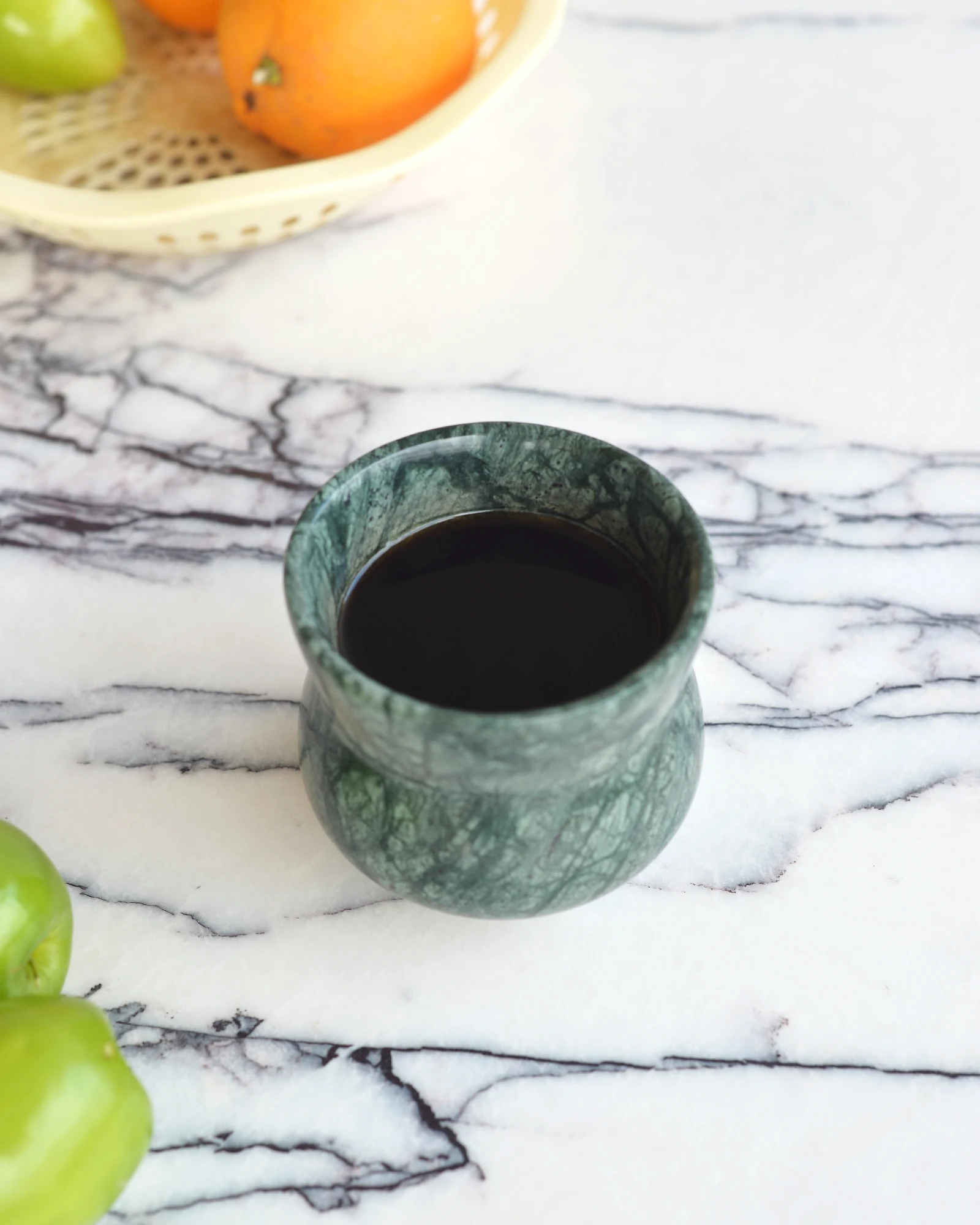 Indian Green Marble Coffee Cup filled with coffee, placed on a white marble tabletop, adding a touch of luxury to the space