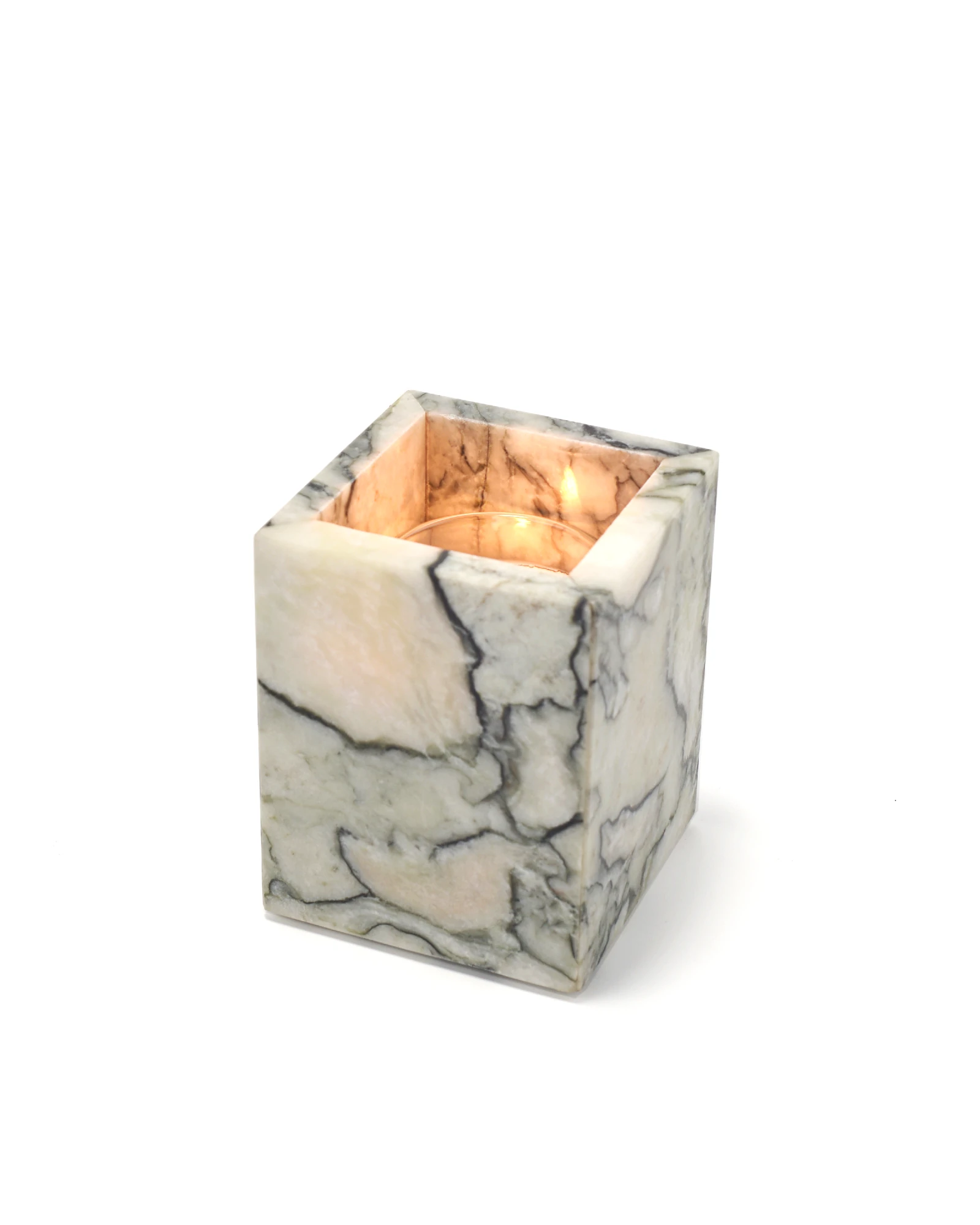 Candlelight glowing through translucent jade marble candle holder