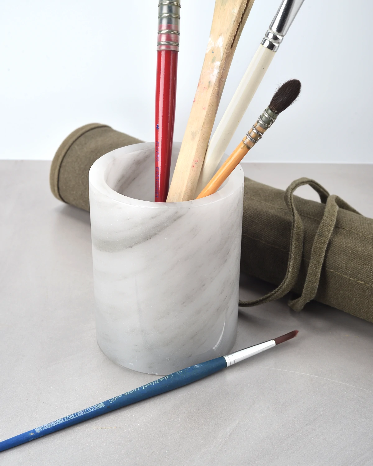 Grey onyx pen holder with pens on a grey tabletop