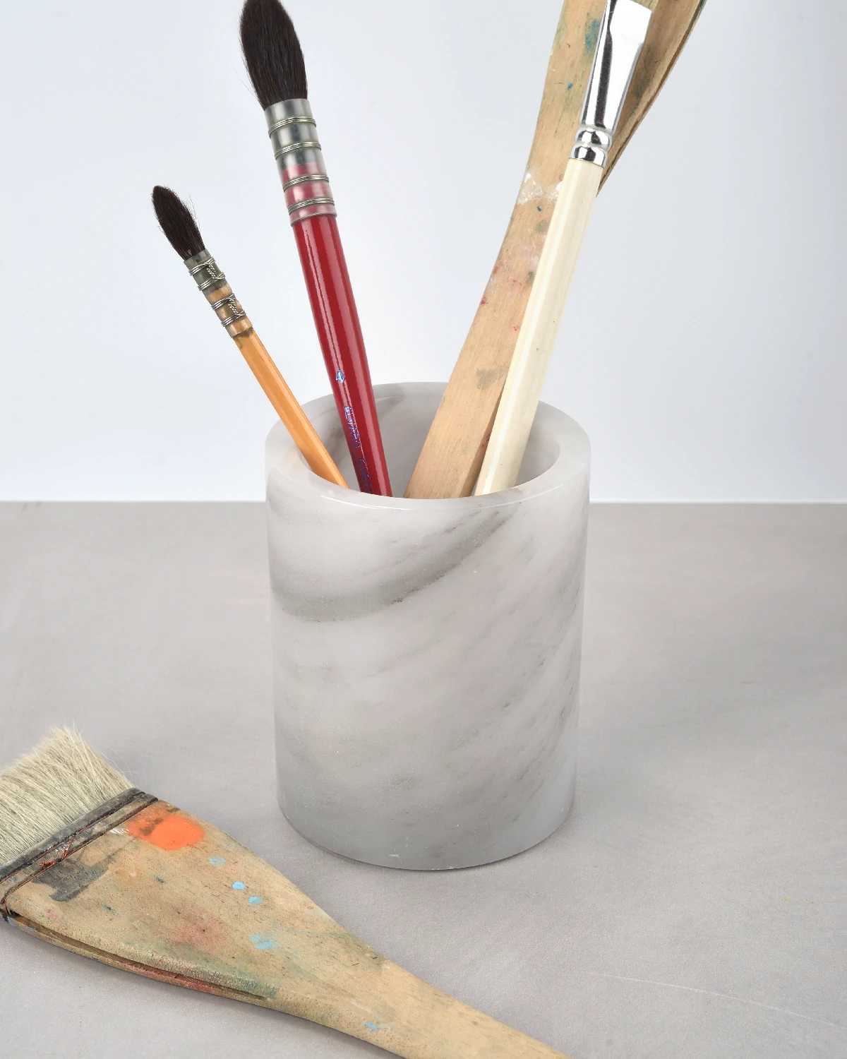 Grey onyx pen holder with watercolor brushes on desktop