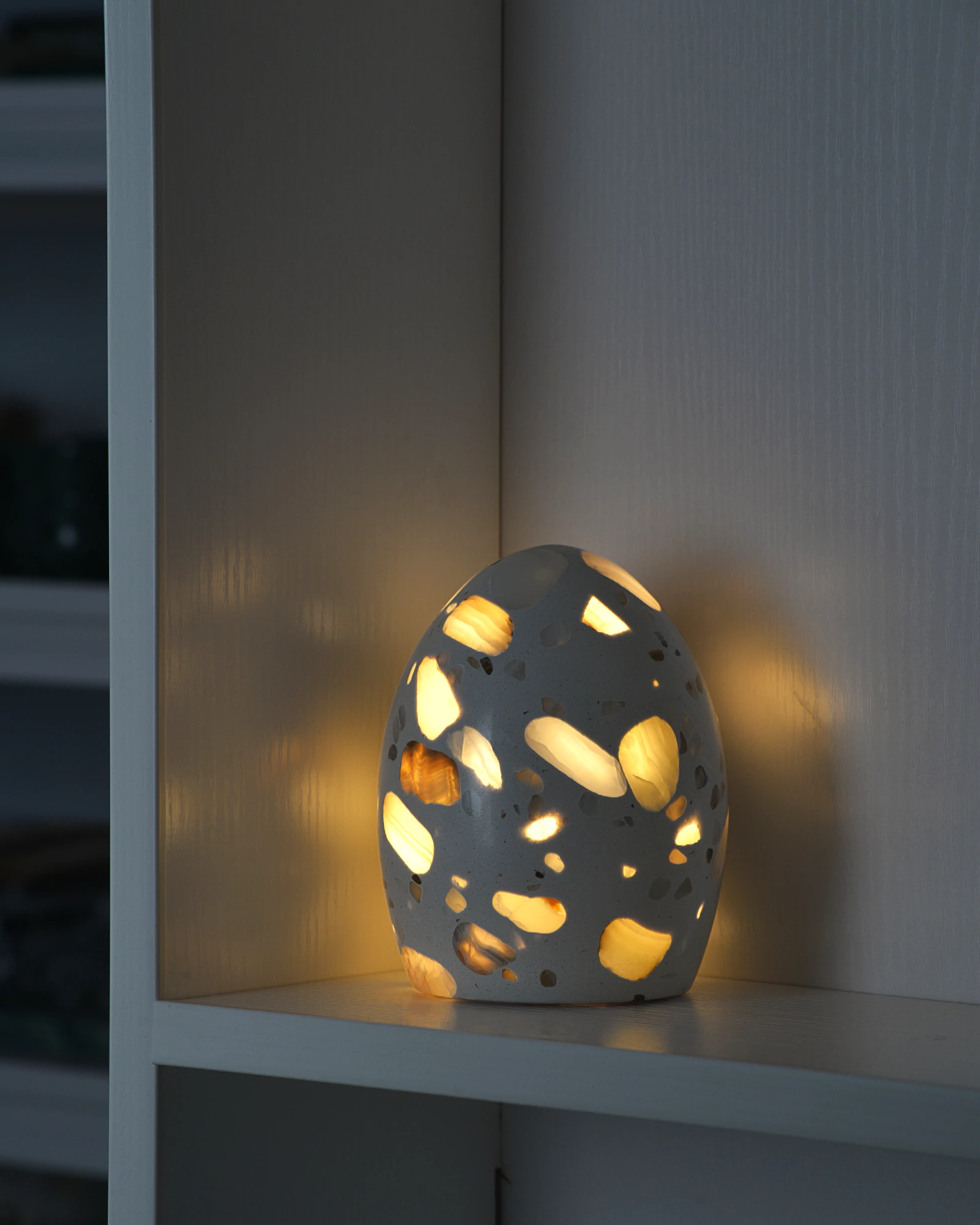 Egg-shaped onyx lamp glowing in a dark room with gemstone-like illumination