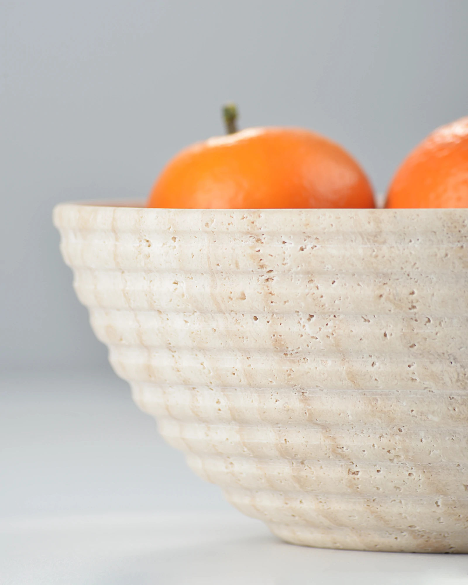 Close-up of travertine bowl’s grooved outer surface with natural pores