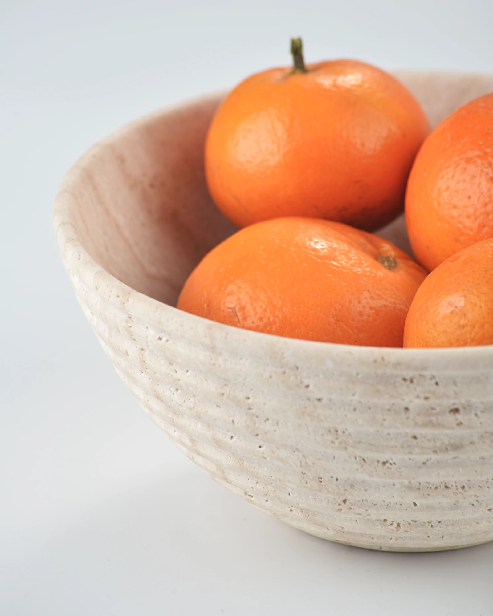 Travertine round bowl with oranges used as a catchall tray or serving bowl