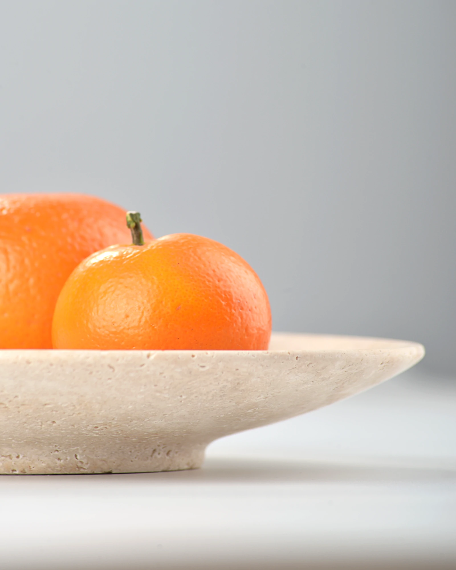 Close-up of travertine plate’s side showing smooth curves and inverted triangle form