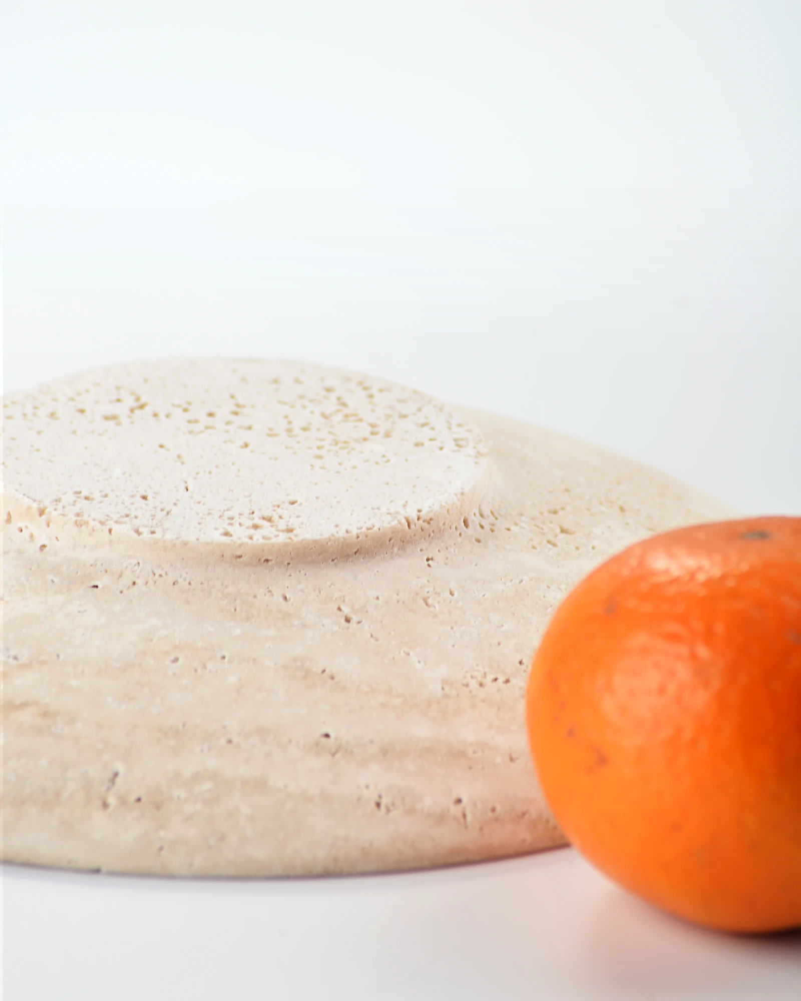 Bottom view of travertine plate showing cylindrical base contact design