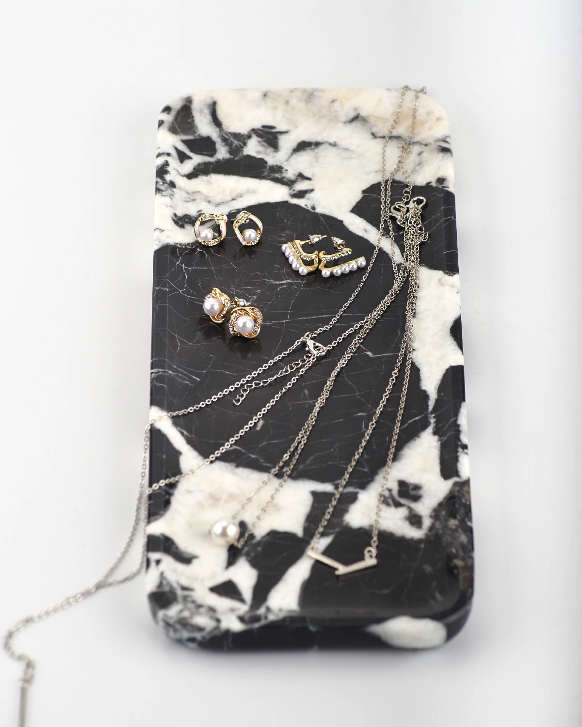Jewelry displayed on polished black marble tray