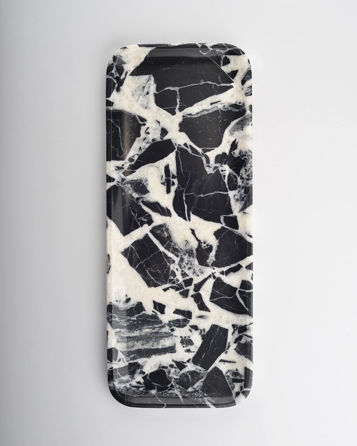 Balanced black and white marble tray resembling a dessert swirl