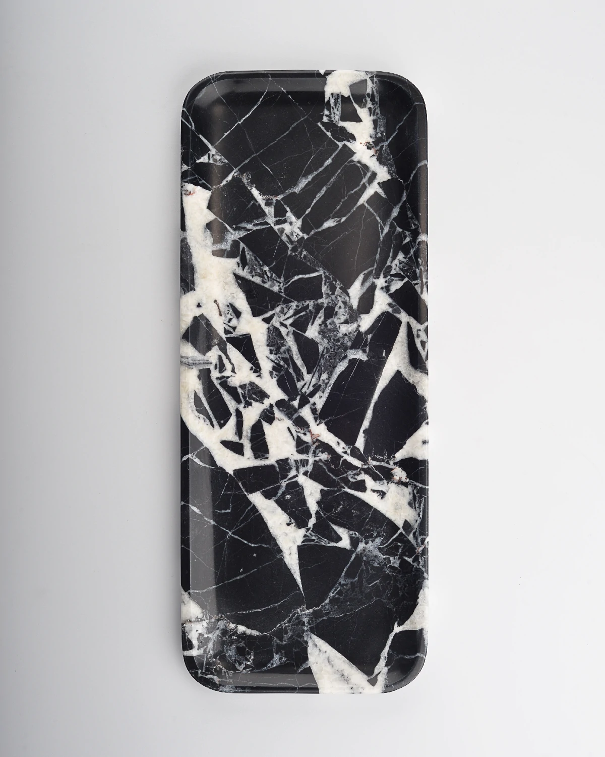 Top view of black marble tray with white web-like veining at center