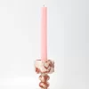 Marble candle holder with lit pink taper candle in classic setting