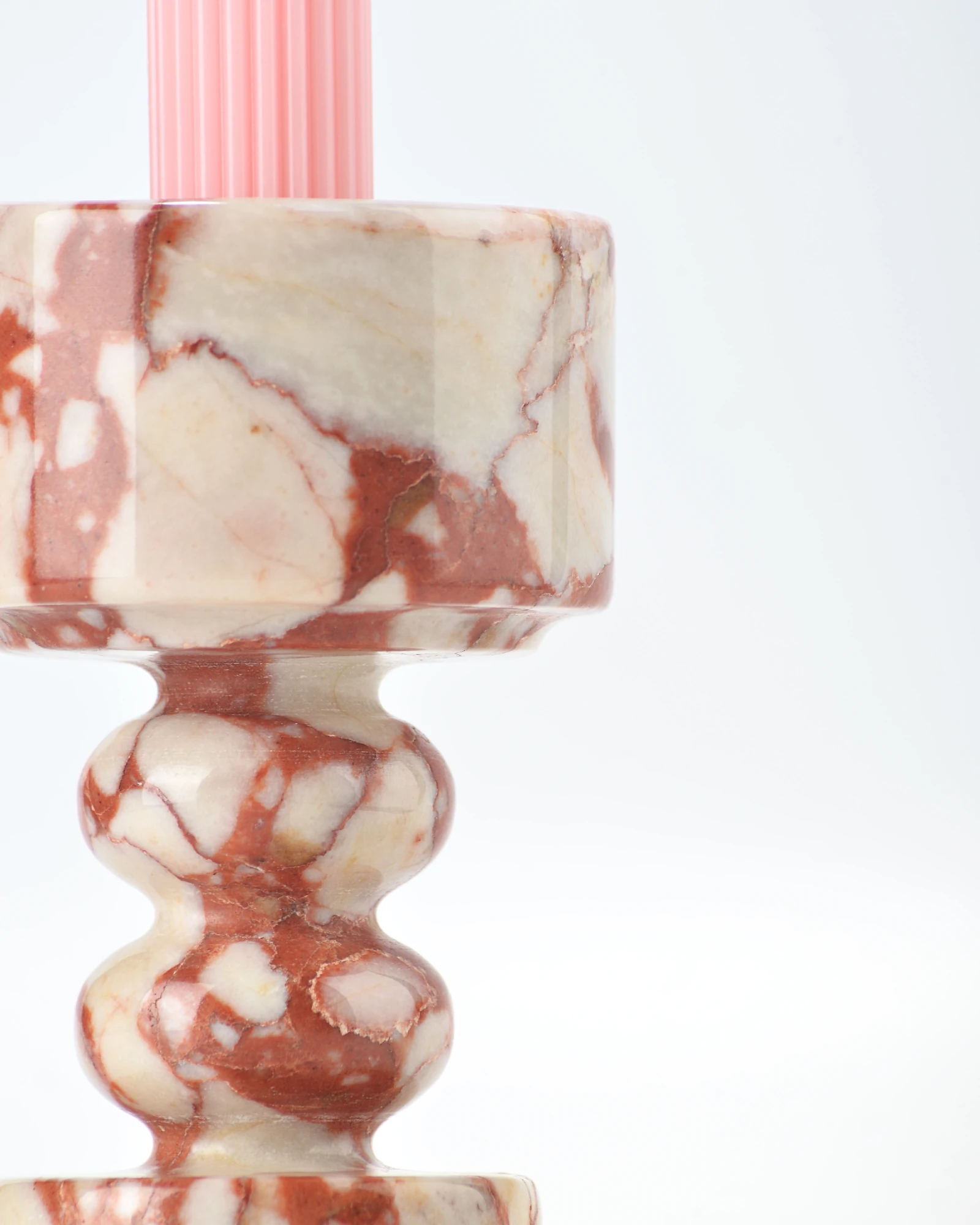 Detail of marble candle holder with goblet form and sculpted wave base