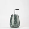 Close-up of small green marble soap dispenser showing leaf-like veining
