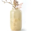 Green onyx vase with light-colored dried flowers reflecting on stone surface