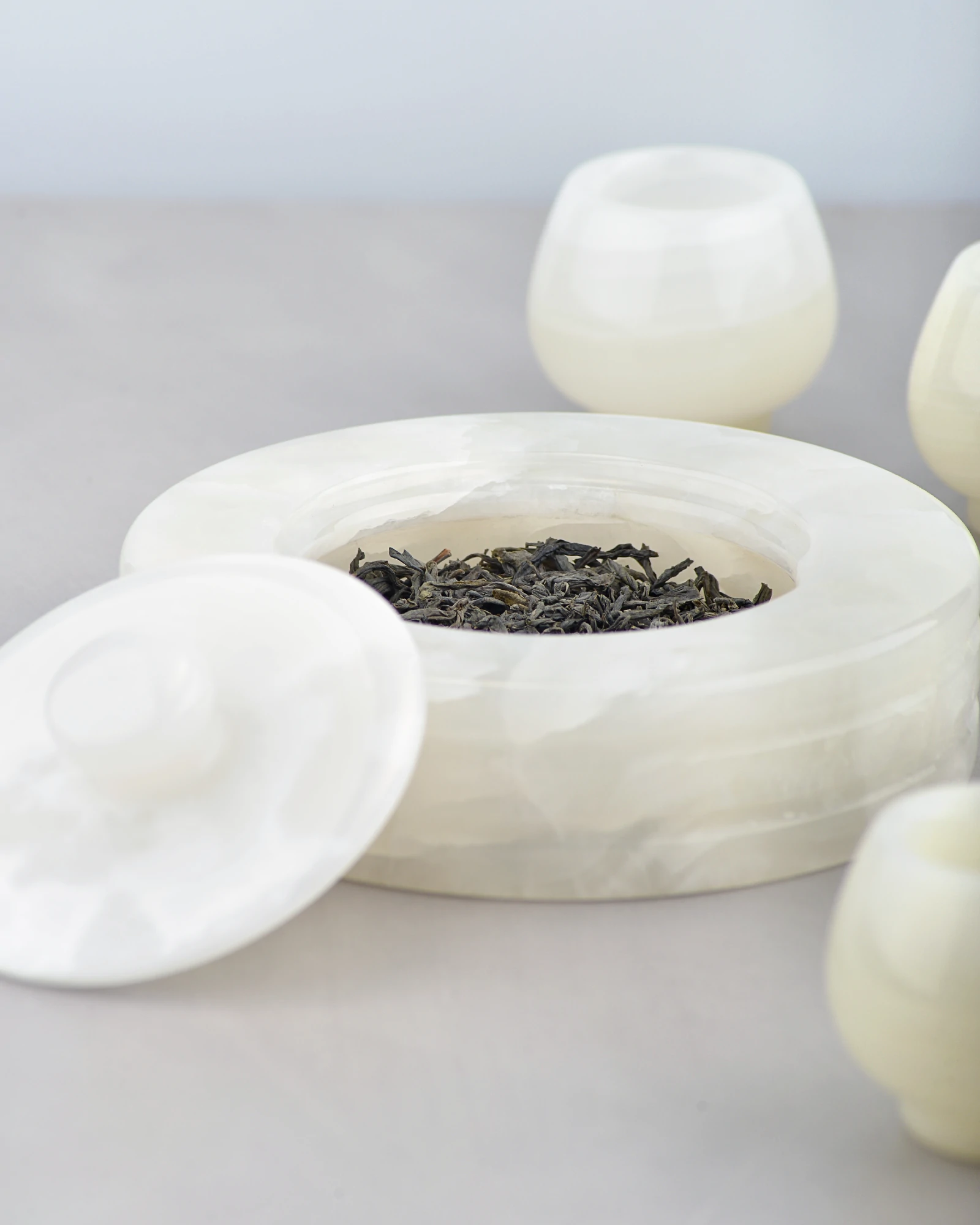 Onyx canister filled with tea, styled with matching stone teacups
