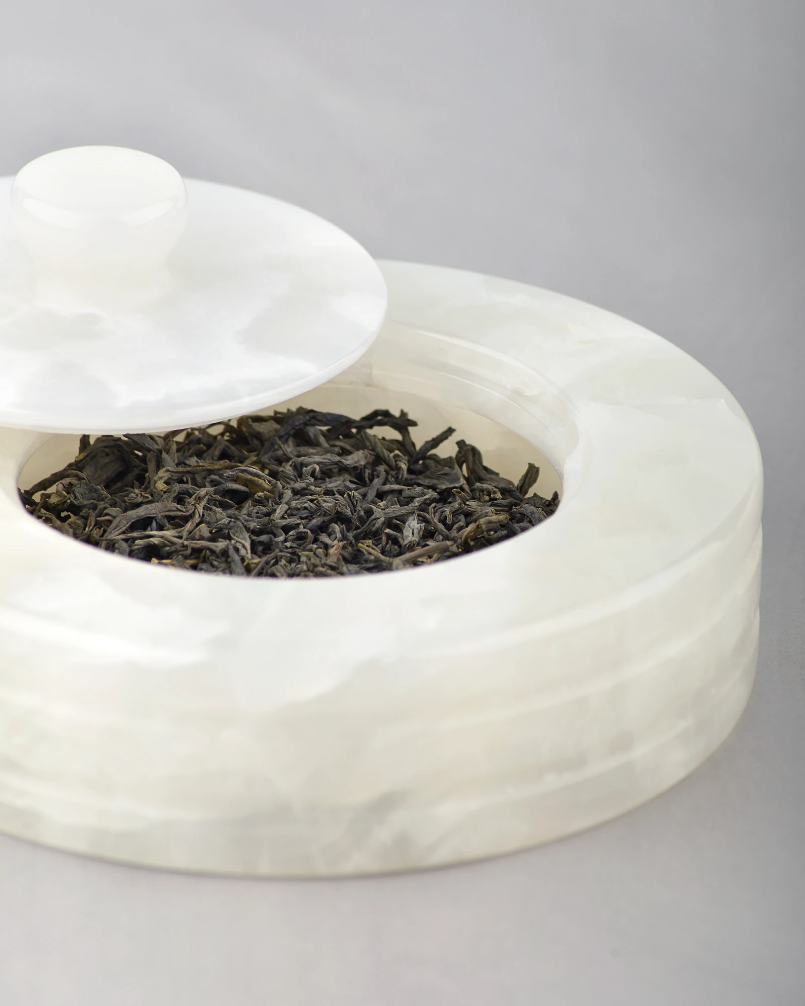 Close-up of polished rim on white onyx canister jar