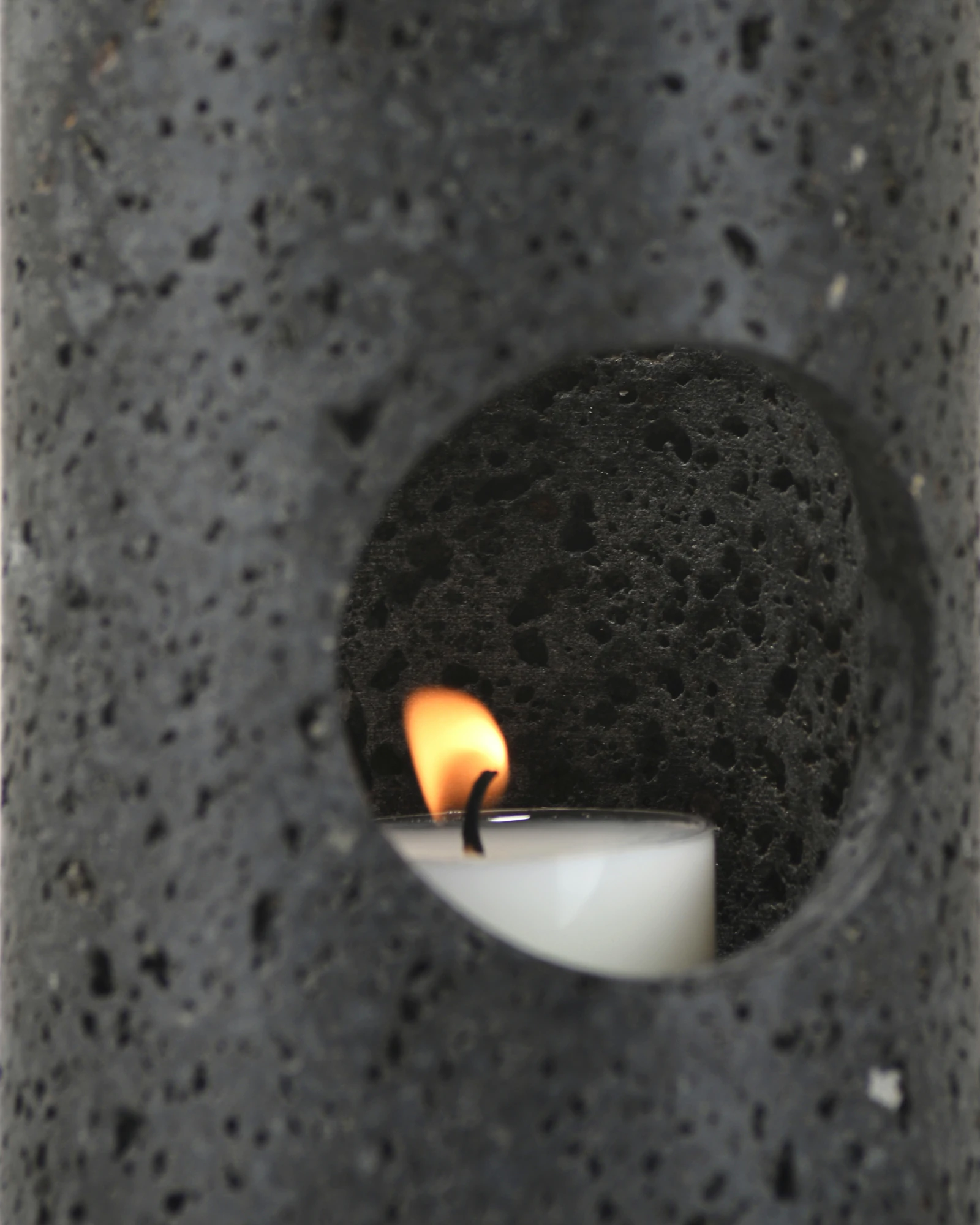 Black Travertine Candle Holder close-up of circular window with candlelight