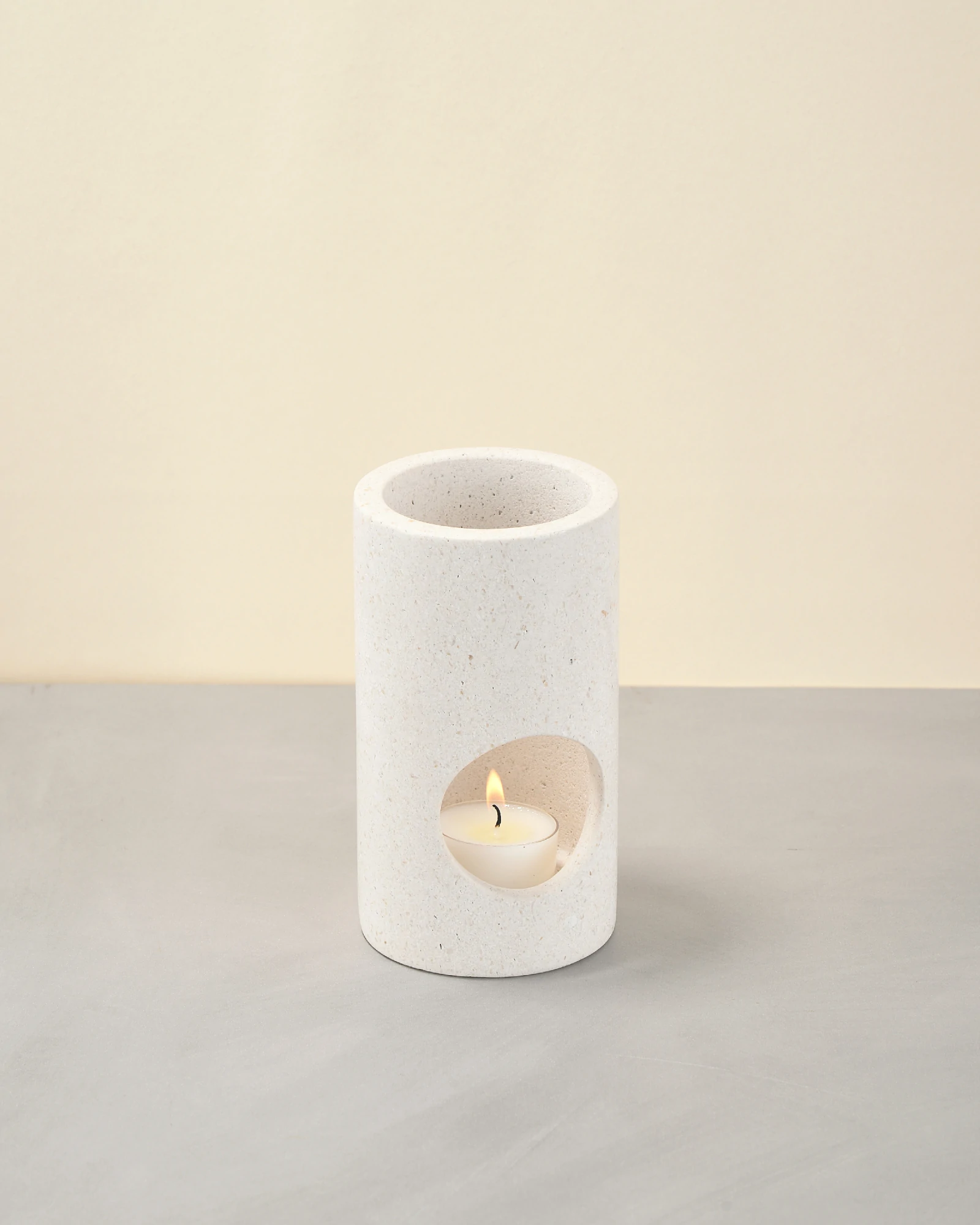 White Stone Candle Holder at 45-degree angle with candlelight glow