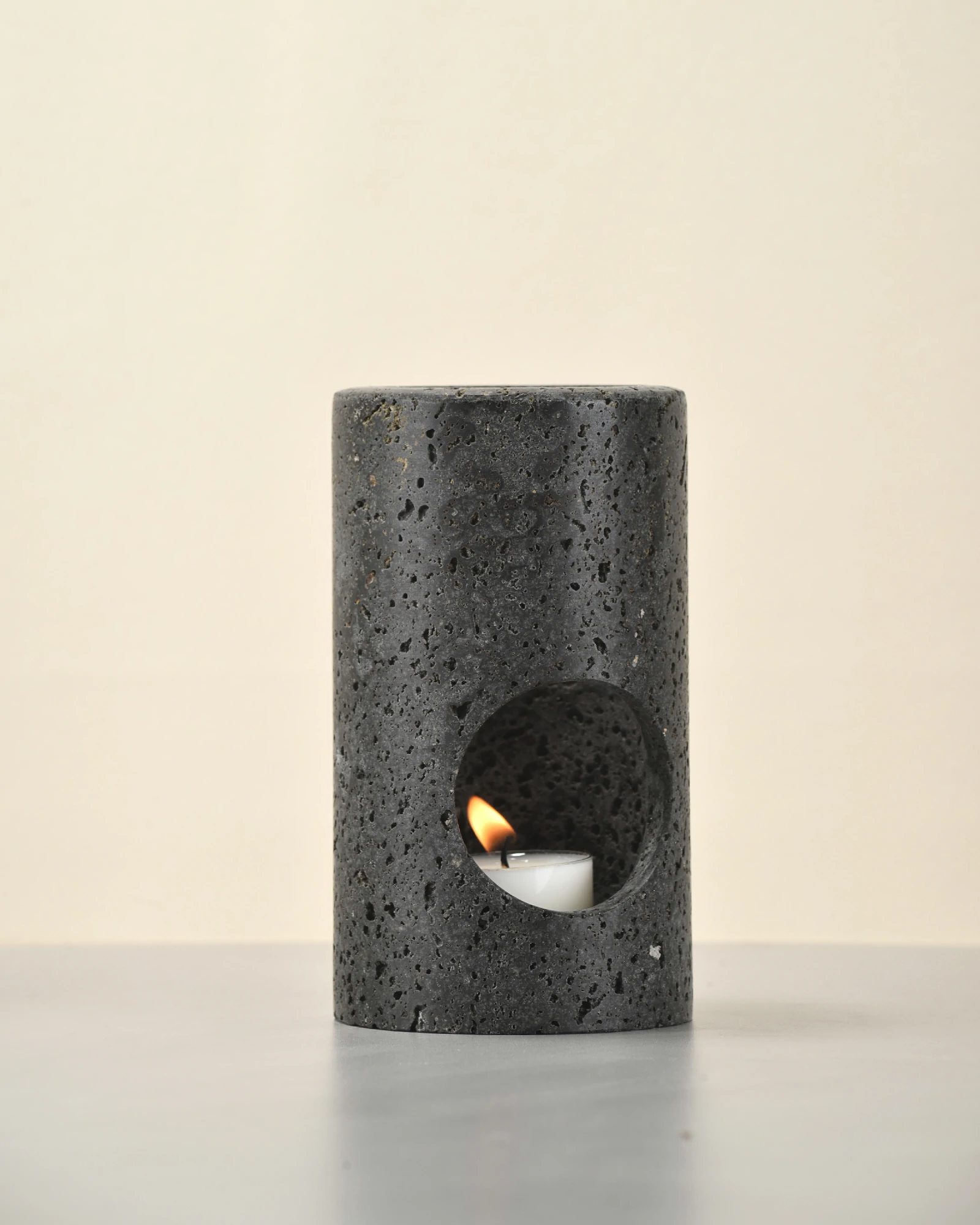 Black Travertine Candle Holder front view with candle lit