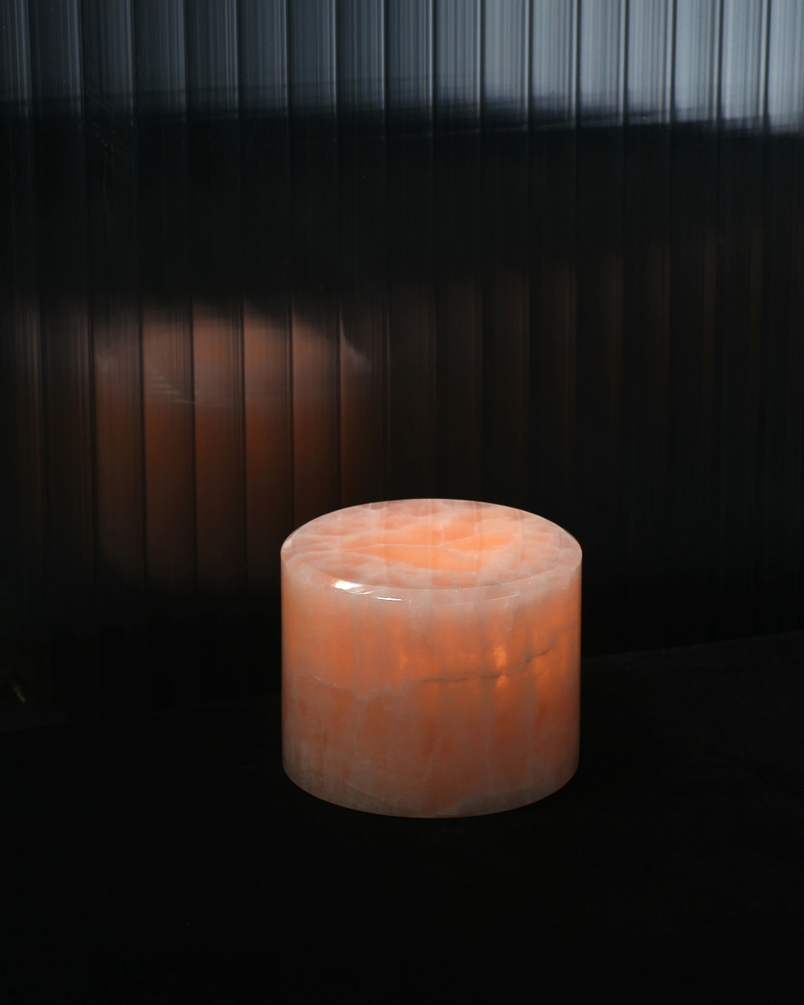 Mini pink onyx table lamp glowing softly in dark setting