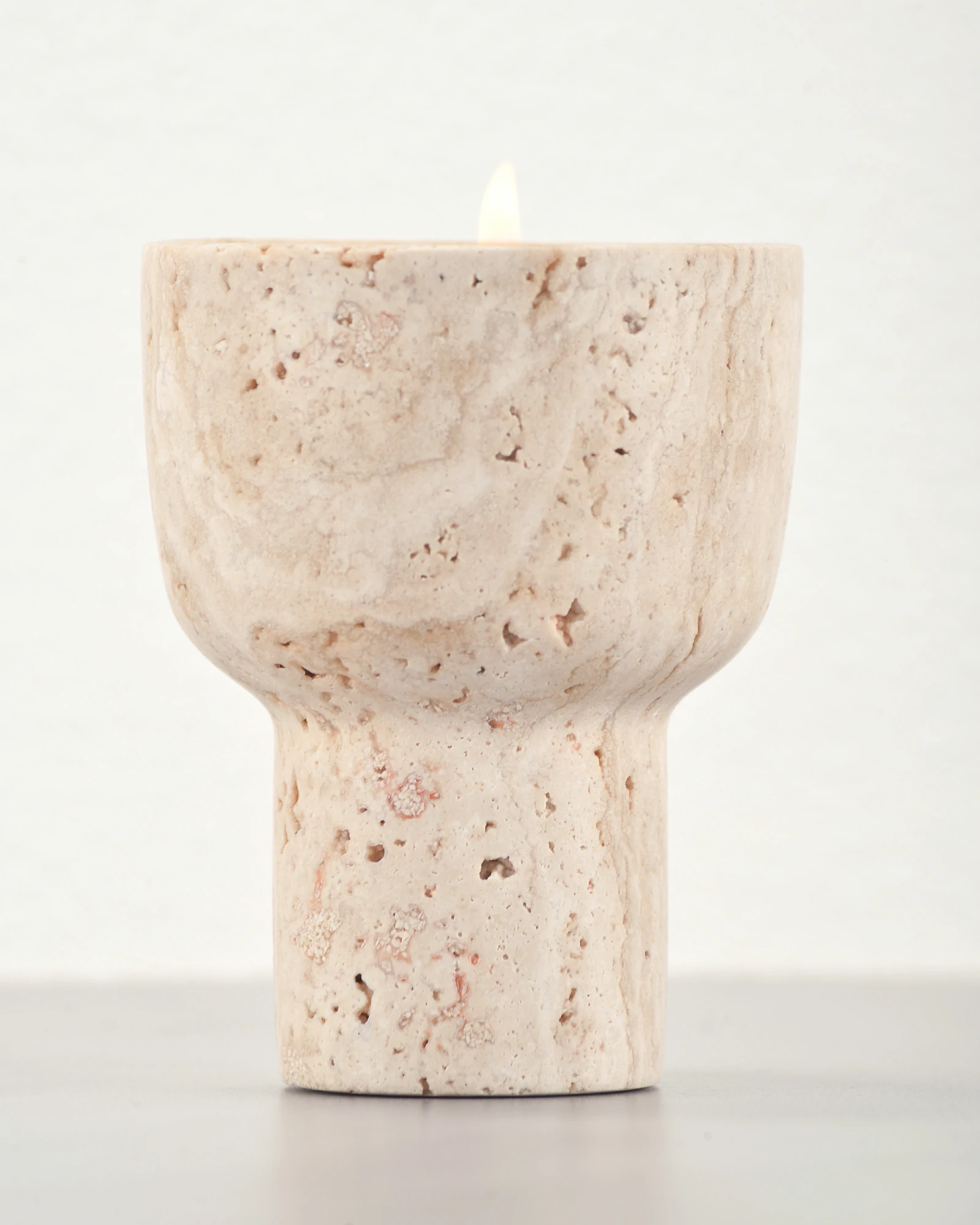 Close-up front view of travertine scented candle holder