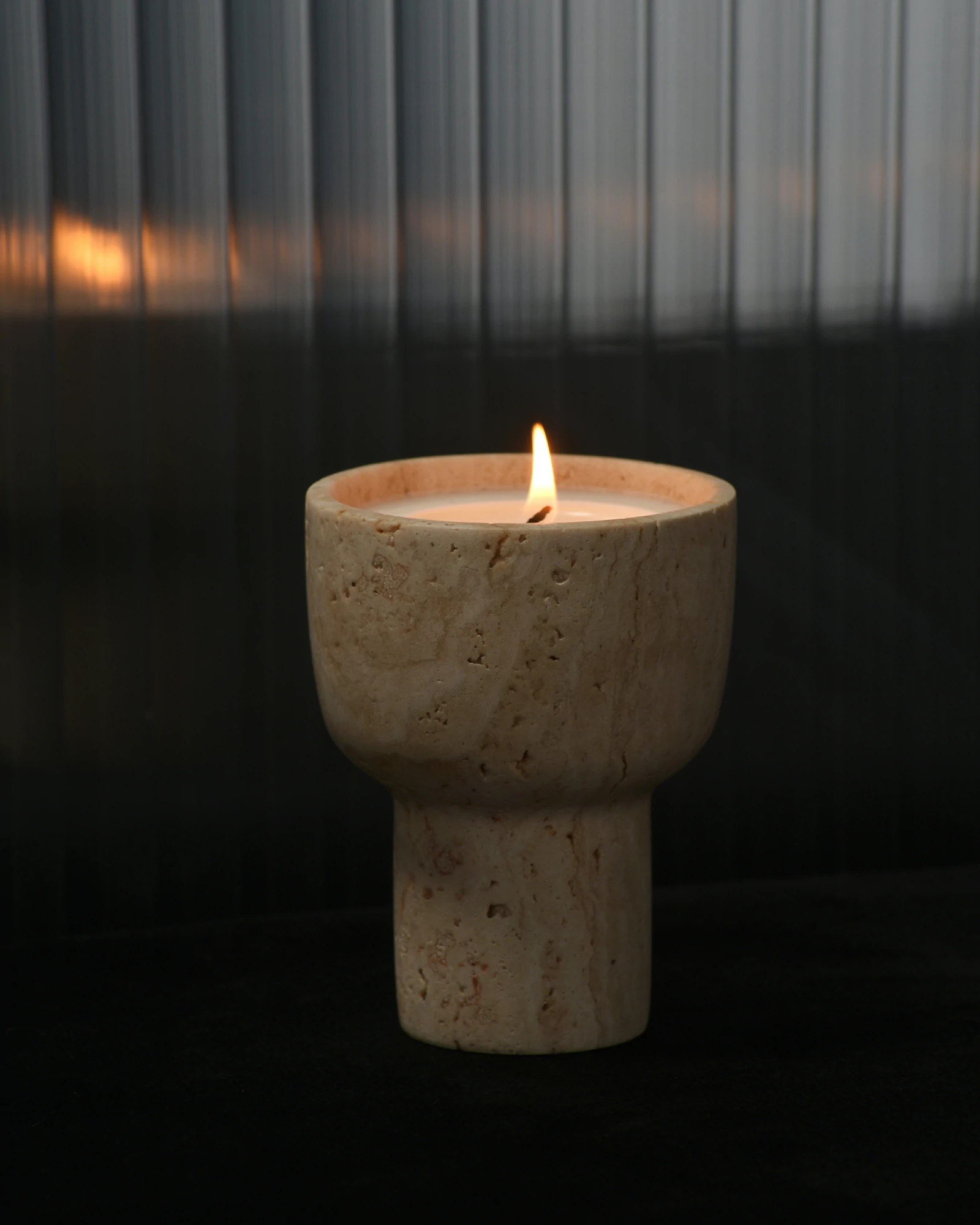Travertine scented candle holder glowing at night