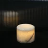 Portable white onyx table lamp glowing softly in dark setting