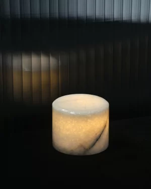 Portable white onyx table lamp glowing softly in dark setting
