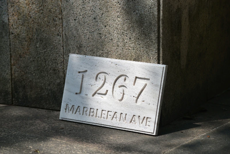 A personalized natural stone address plaque installed at a modern home entrance.