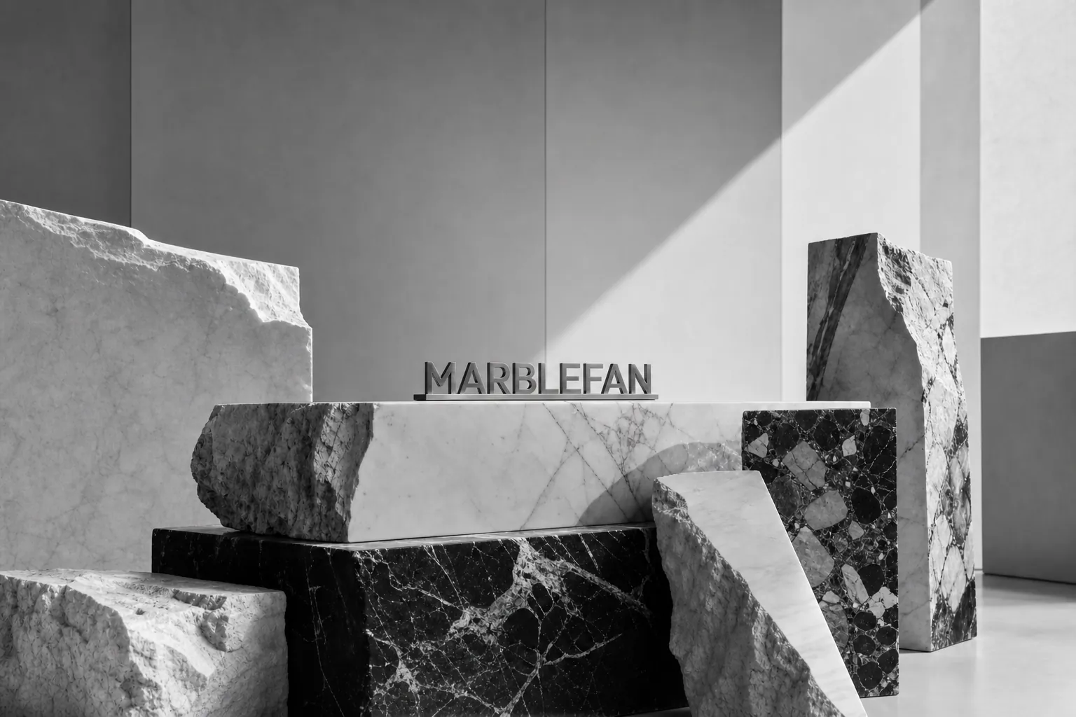 Brushed stainless steel MarbleFan sign displayed on assorted black and white raw marble blocks.