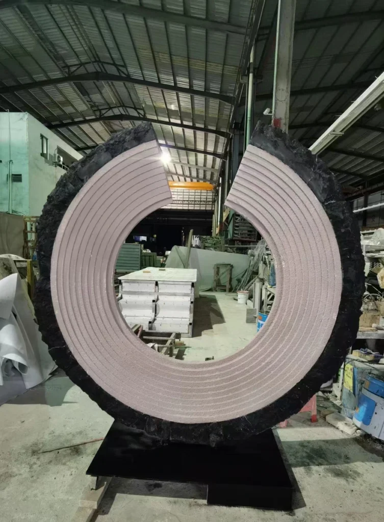C-shaped Black & White Root Marble sculpture during factory trial assembly