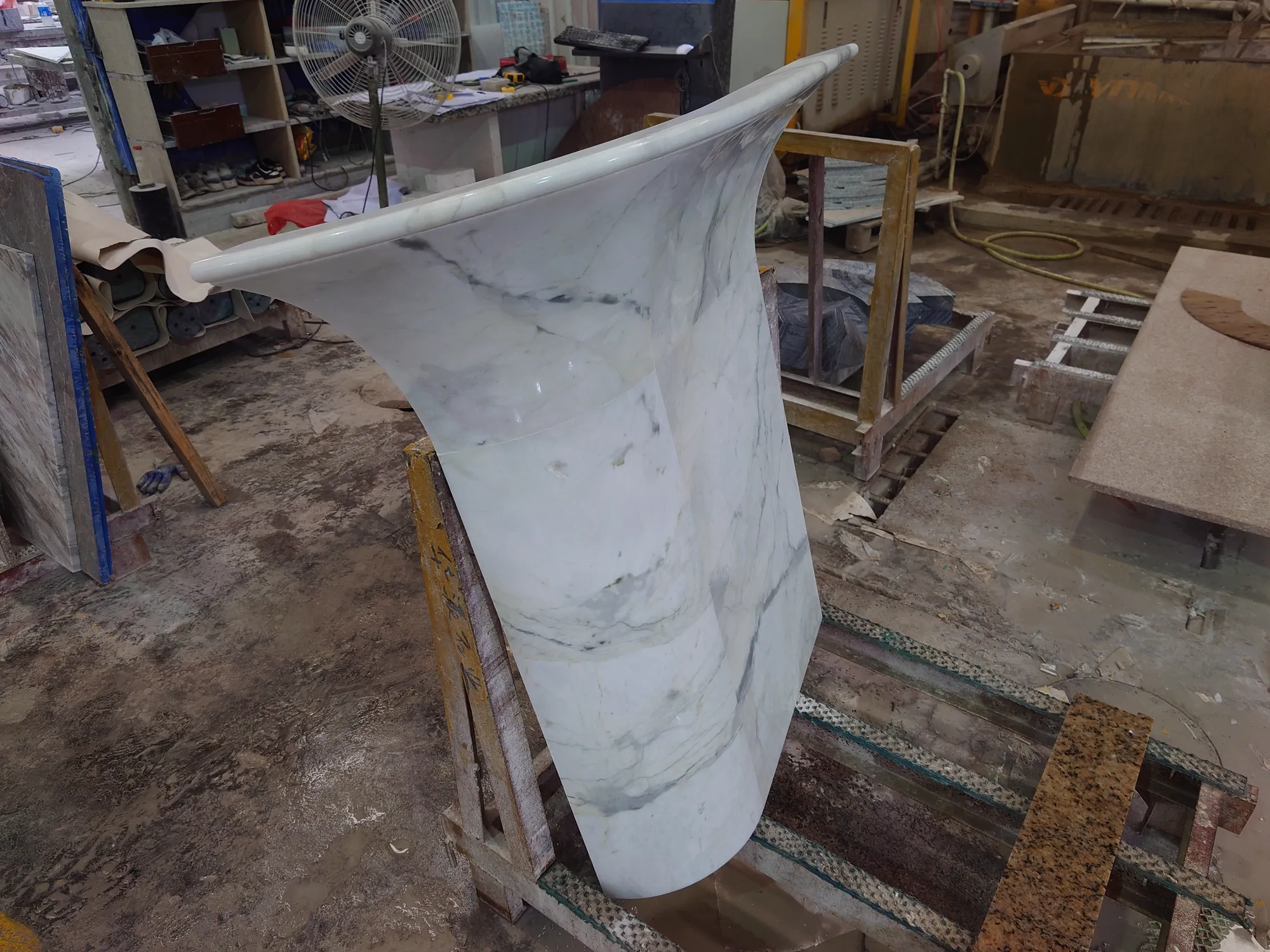 Bonded Fish Belly White curved counter component during water grinding.