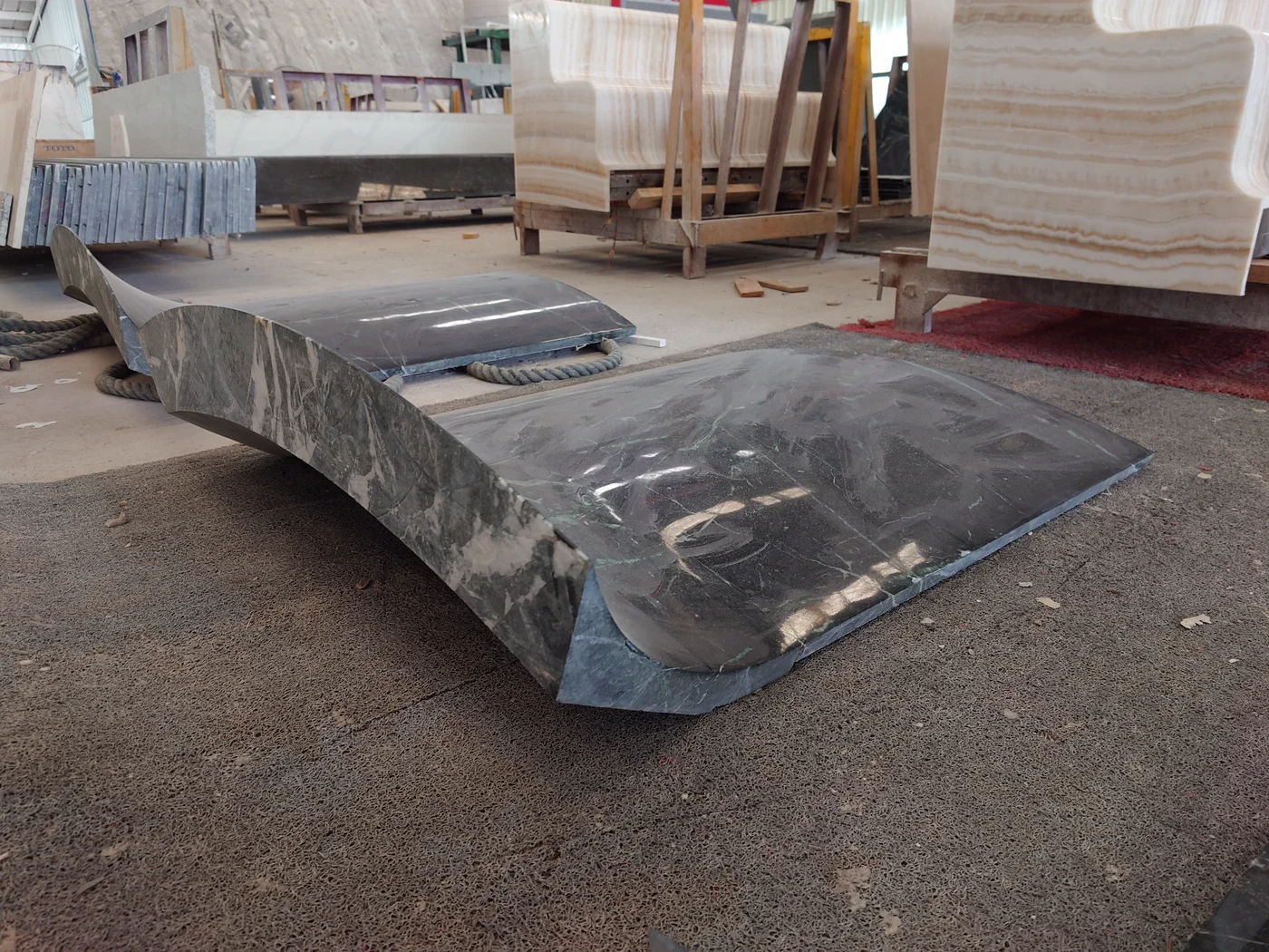 Prada Green marble curved counter parts separated for water grinding.
