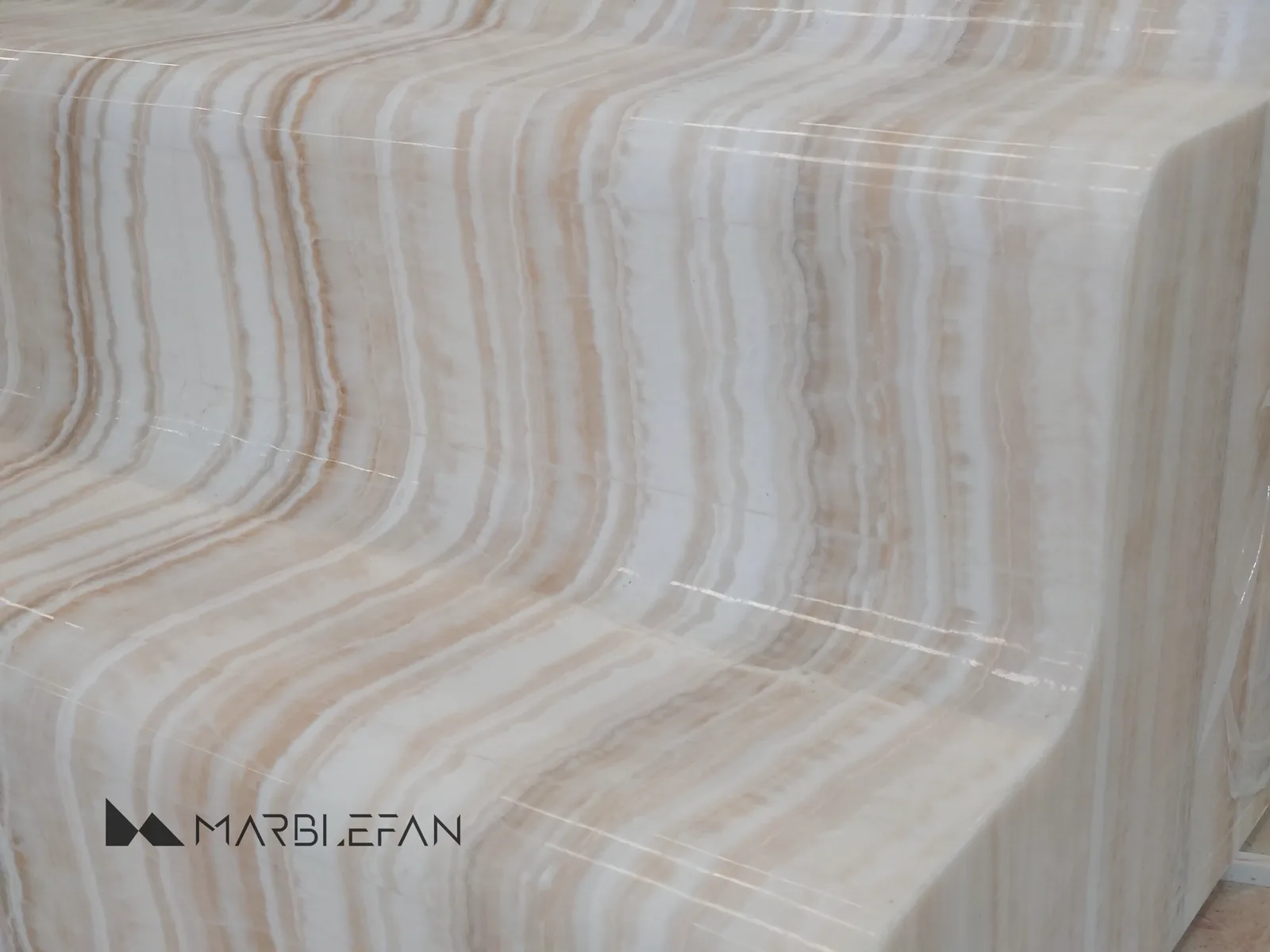 Finished stepped marble table end showing continuous natural veining.