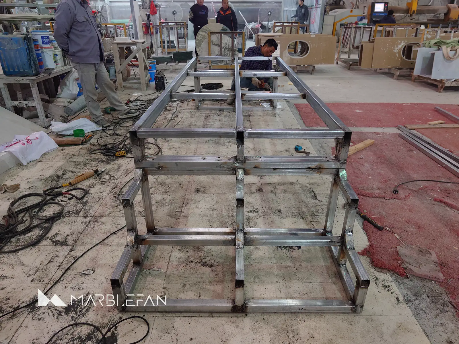 Custom steel table frame during workshop fabrication.
