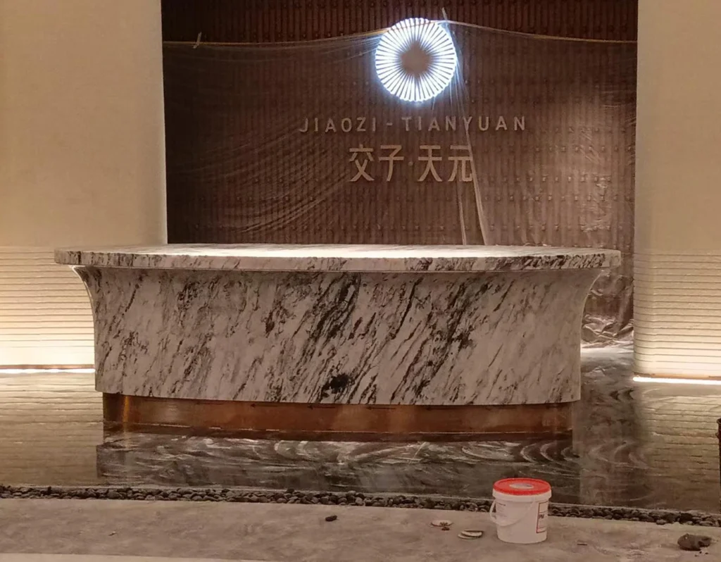 Completed curved marble reception desk installed in a commercial reception area