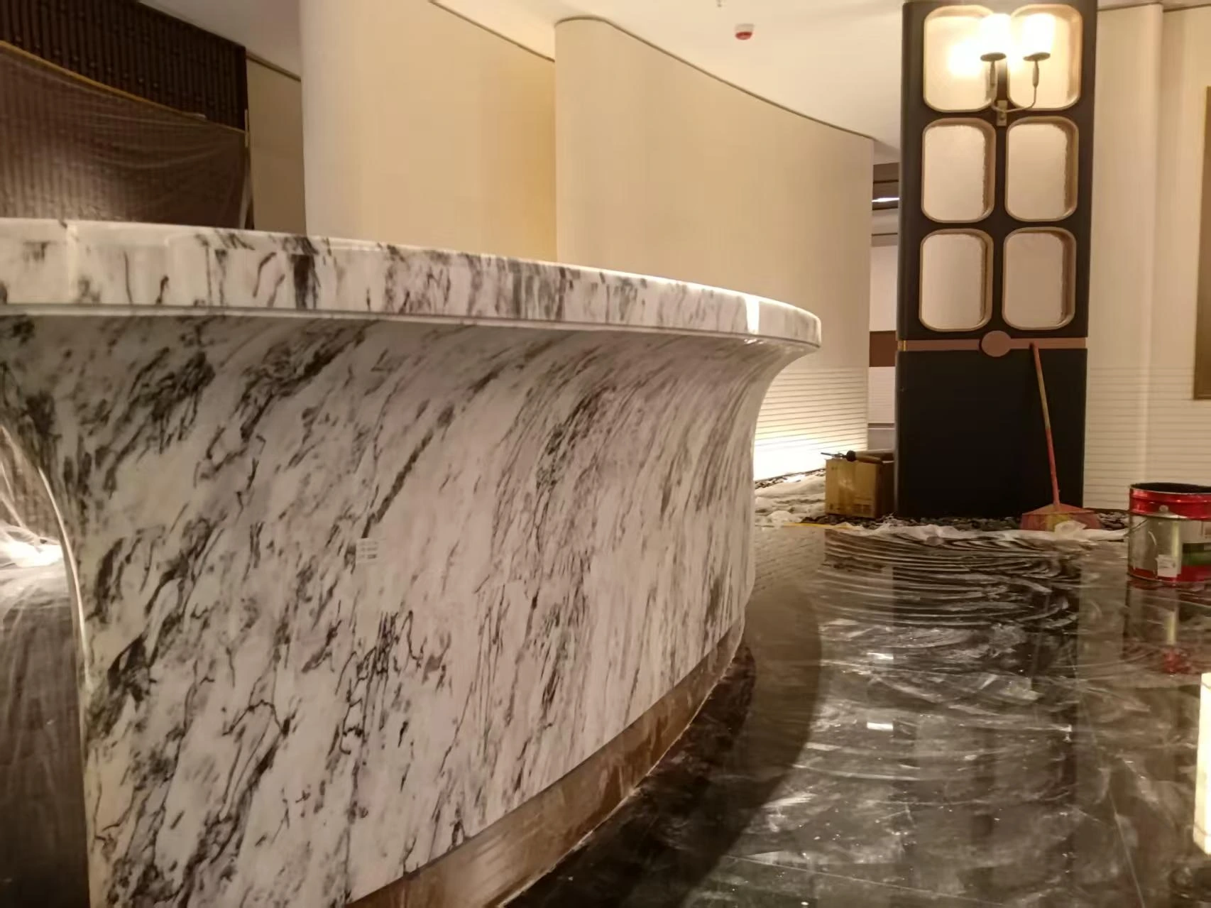 Installed curved marble reception desk with blue-gray veining