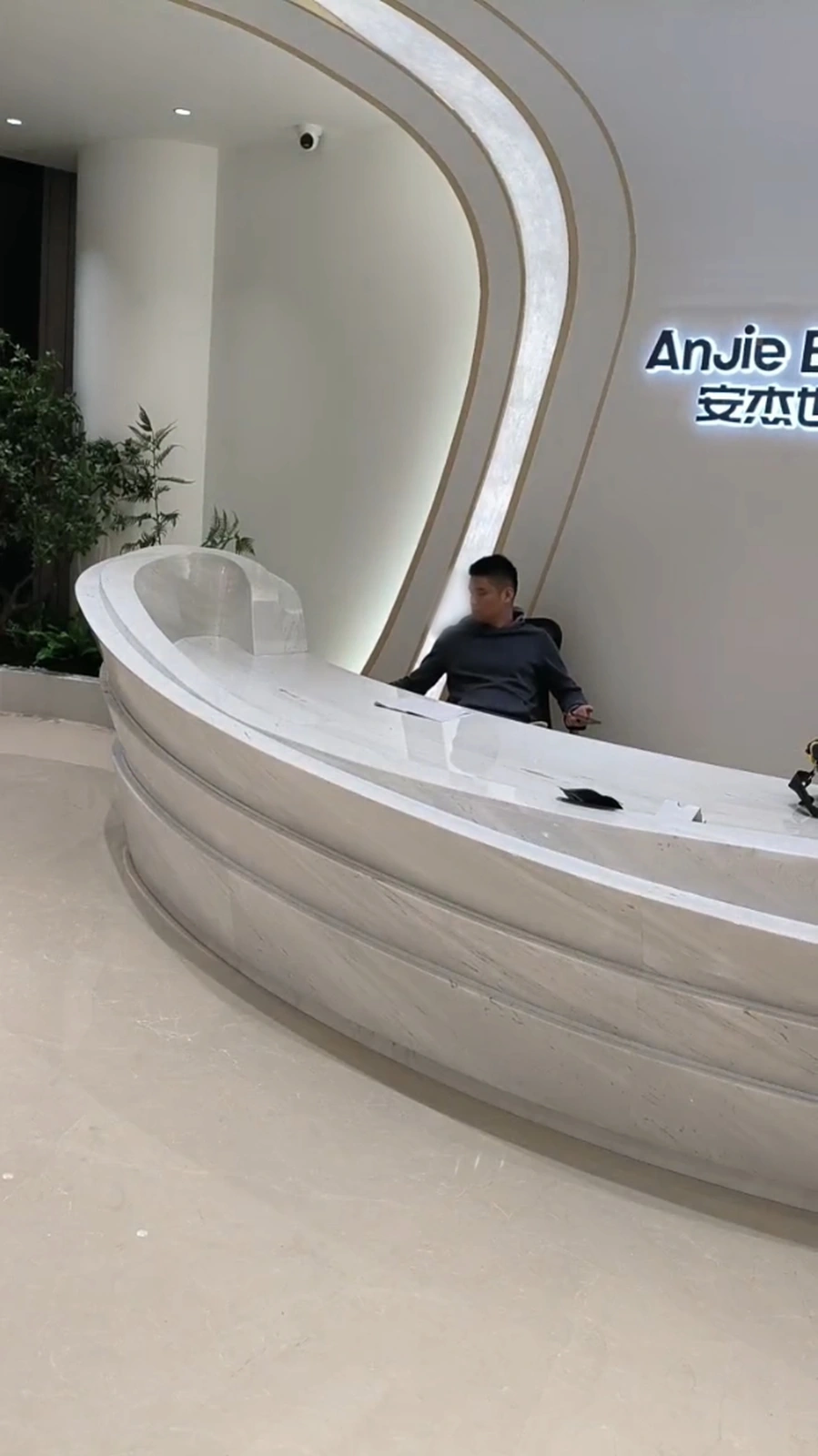 Completed Sivec marble reception desk under ambient lobby lighting